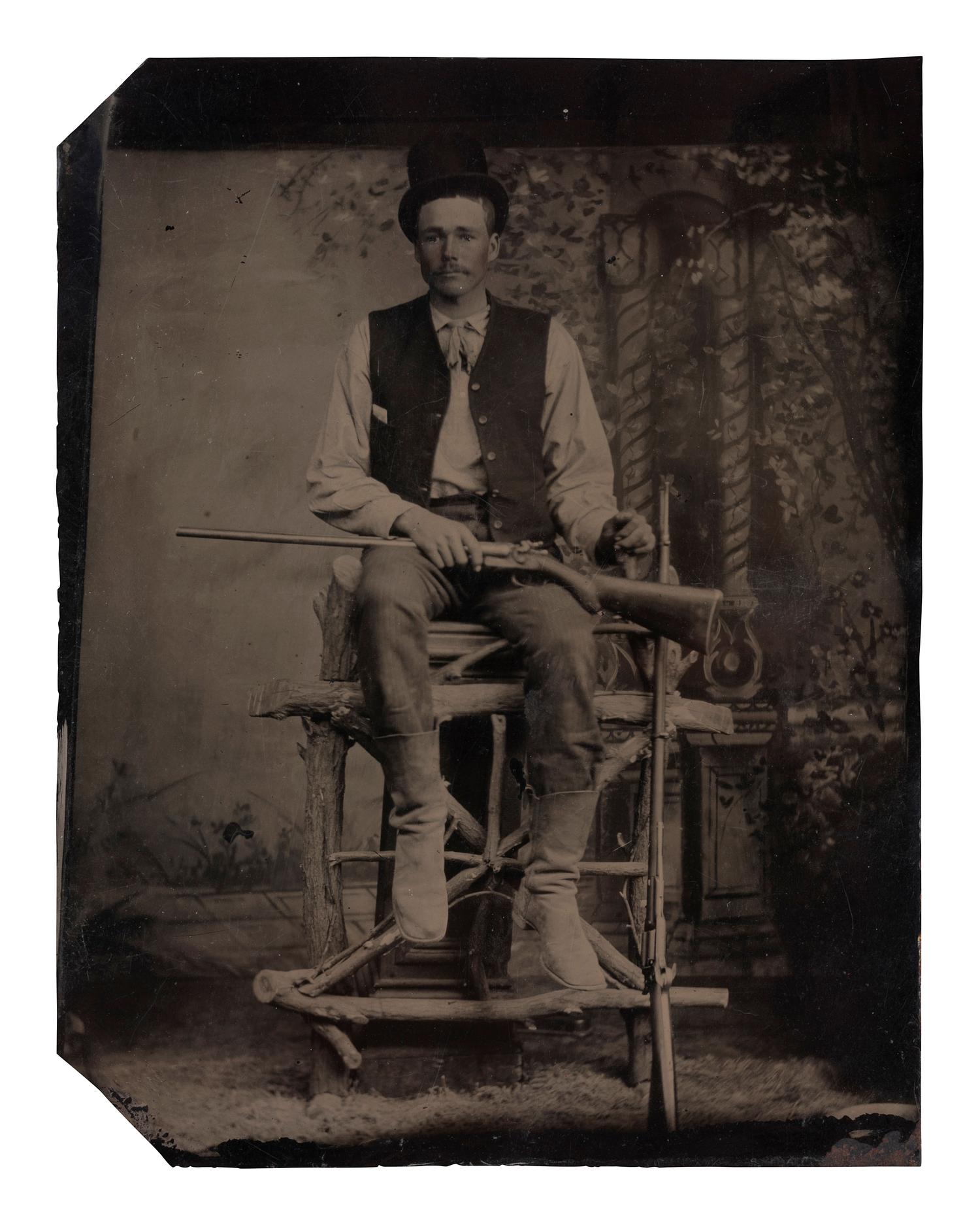 [EARLY PHOTOGRAPHY]. Tintype of man with a Colt revolving rifle and shotgun.