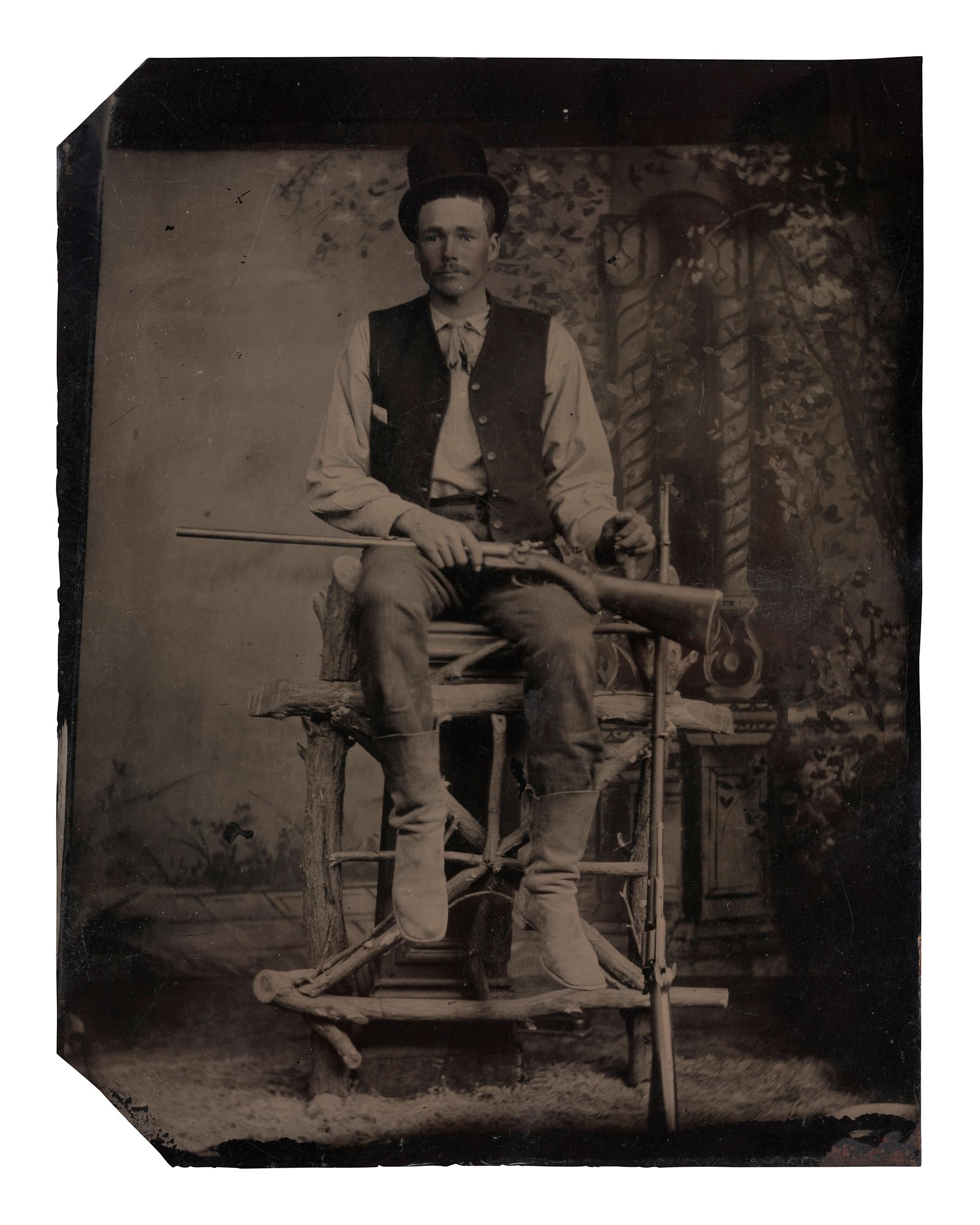 [EARLY PHOTOGRAPHY]. Tintype of man with a Colt revolving rifle and shotgun.