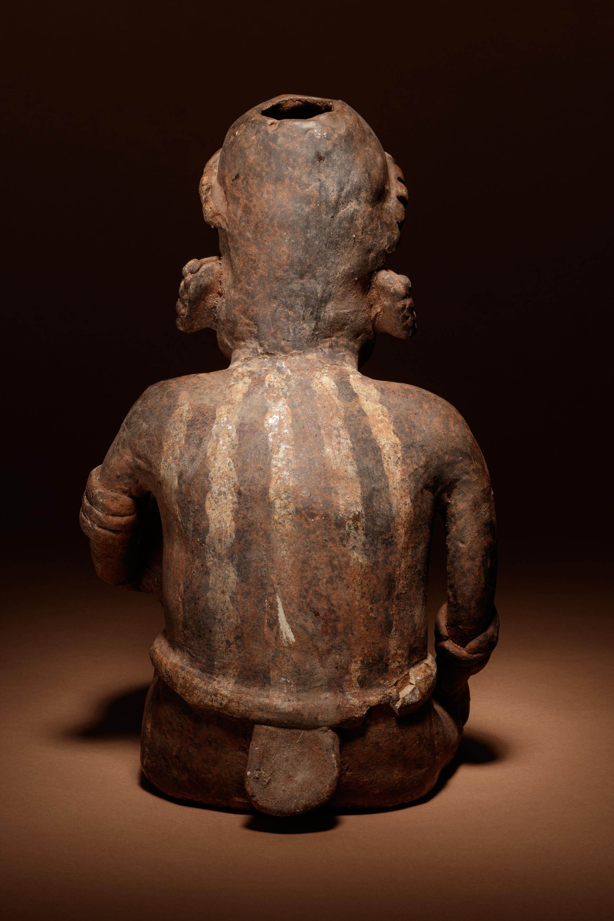 A Nayarit Terracotta Crouching Figure with Vessel