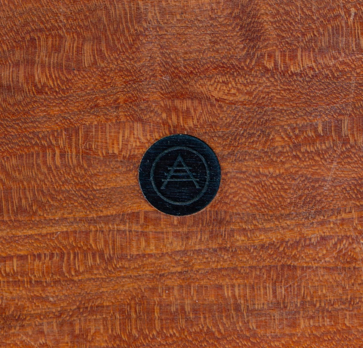 A Modern Stool, c. 20th Century, the circular seat centered by an inset designer logo and raised on three tapering cylindrical legs joi