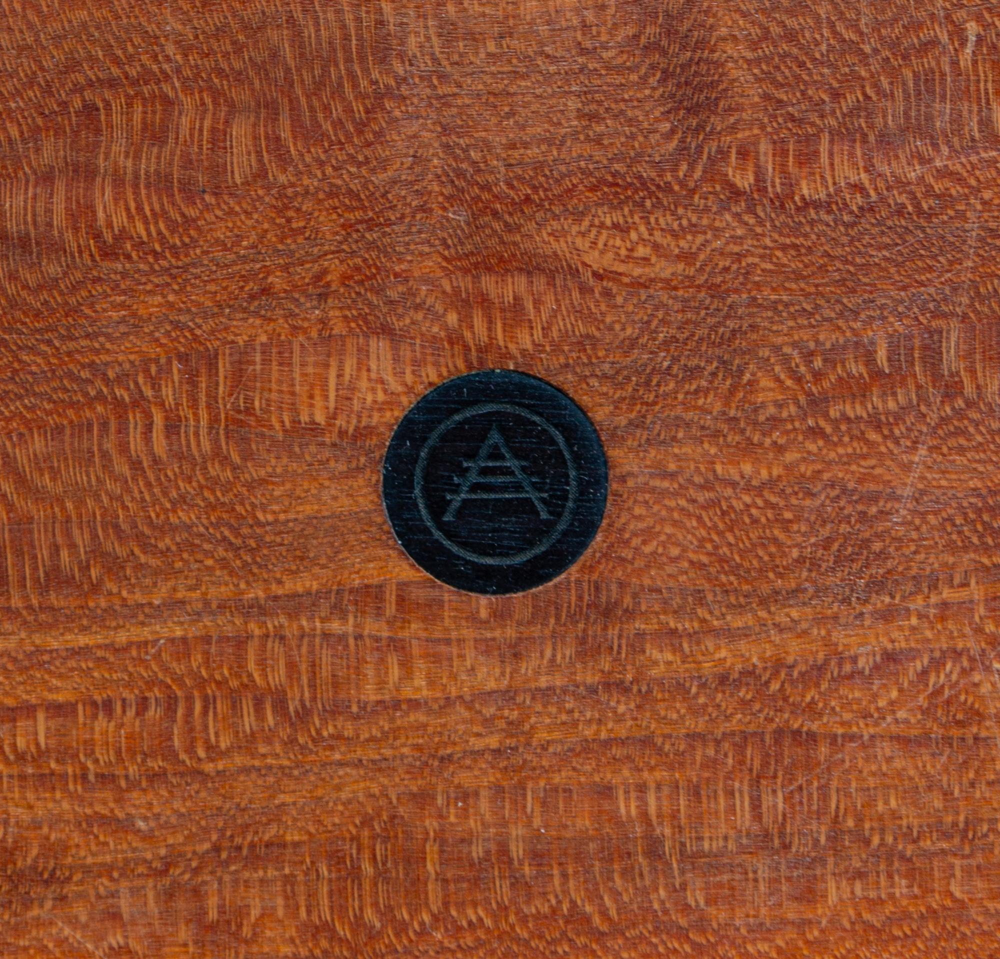 A Modern Stool, c. 20th Century, the circular seat centered by an inset designer logo and raised on three tapering cylindrical legs joi
