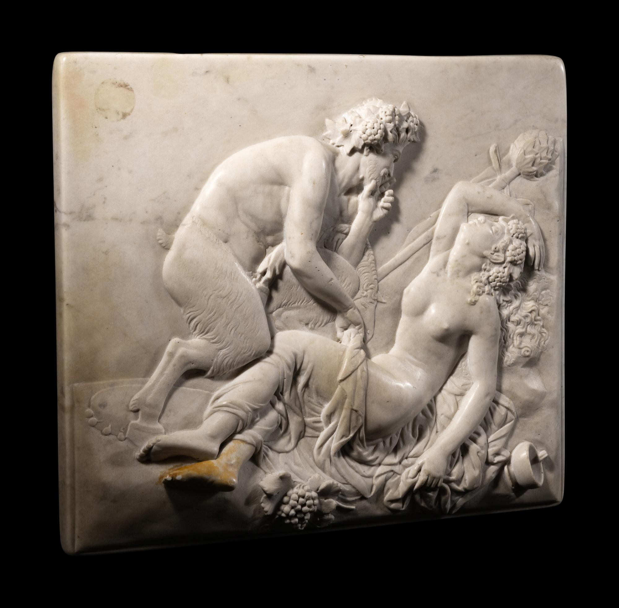 A Continental Carved Marble Relief Depicting a Satyr and a Bacchante