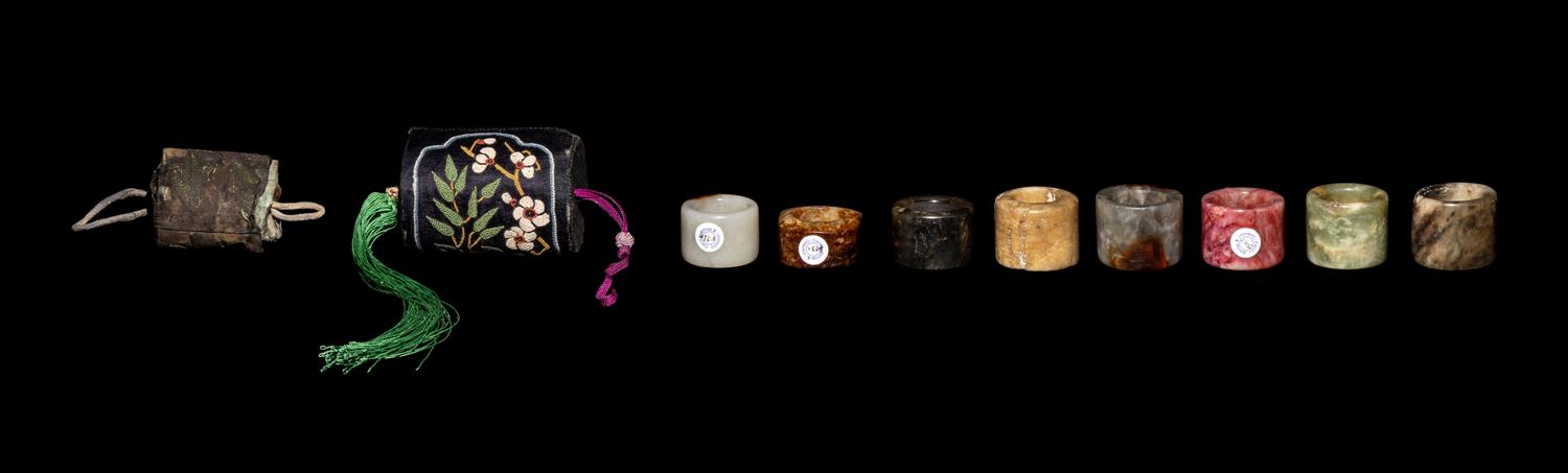 A Group of Chinese Jade and Hardstone Archers Rings with an Embroidered Silk Case