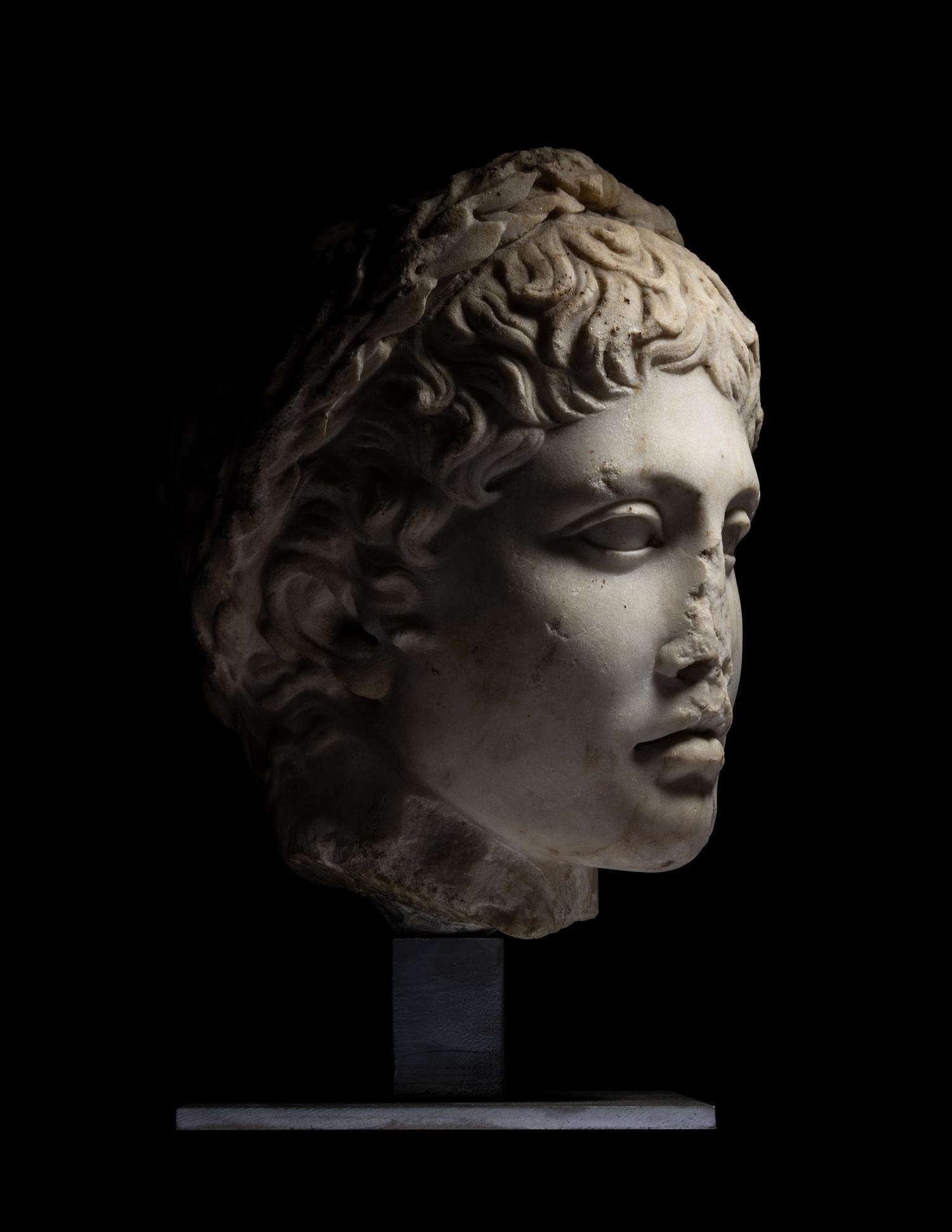 A Roman Marble Head of a Youth Wearing a Laurel Wreath