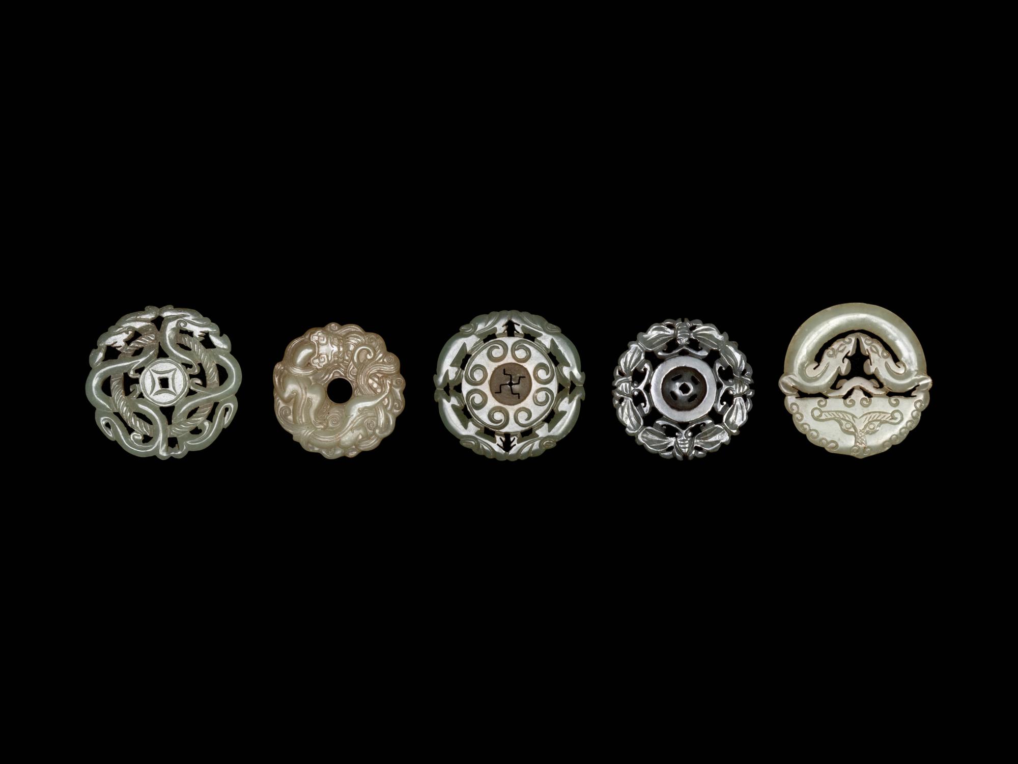 Five Chinese Pale Celadon Jade Carved and Reticulated Circular Pendants