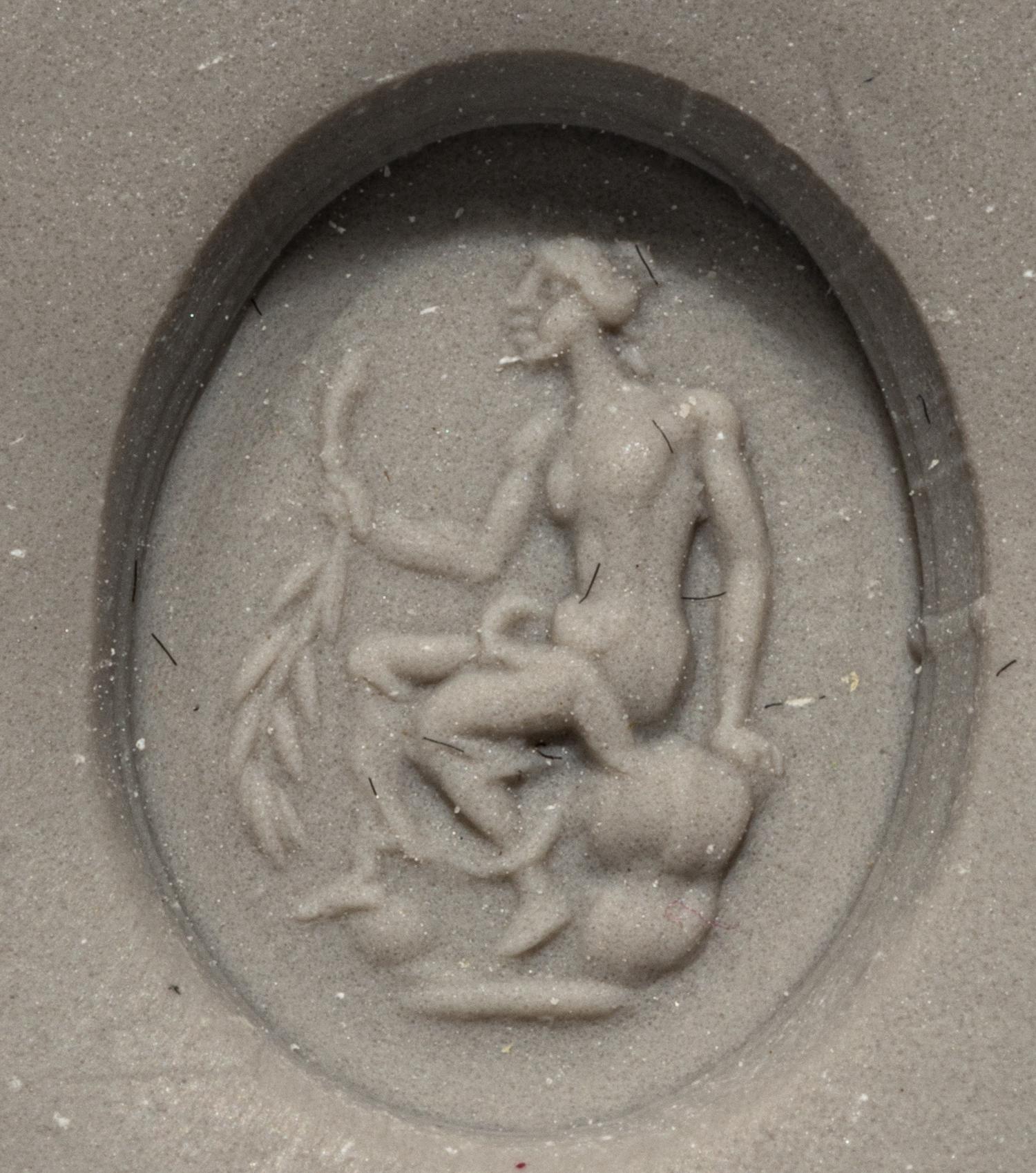 A Roman White Glass Ring Stone with Andromache or Calliope Seated and Holding a Palm Branch