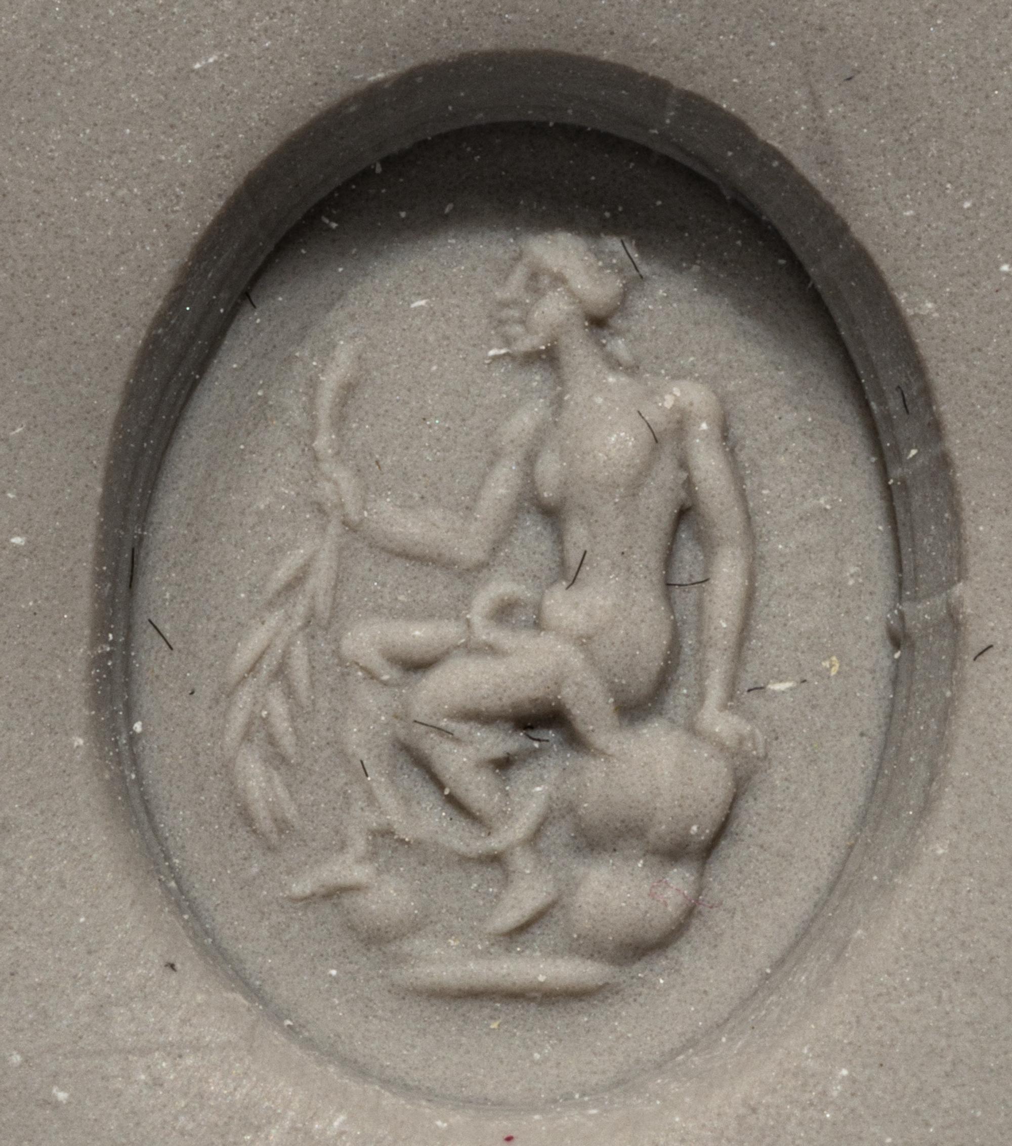 A Roman White Glass Ring Stone with Andromache or Calliope Seated and Holding a Palm Branch