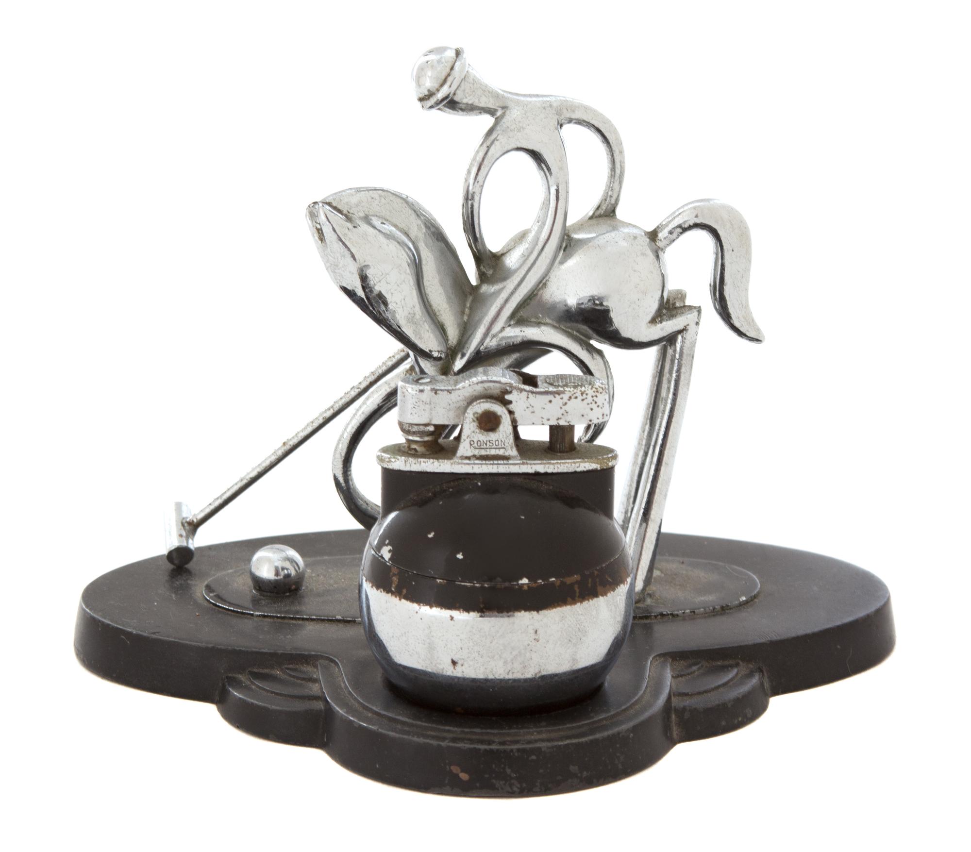 A Chromed Metal Polo Player-Form Ronson Cigarette Lighter Stand Height 4 1/2 x width 5 1/8 x depth 4 inches. — 20TH CENTURY