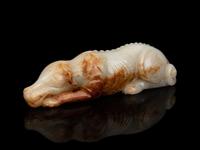 A White and Russet Jade Figure of a Recumbent Dog