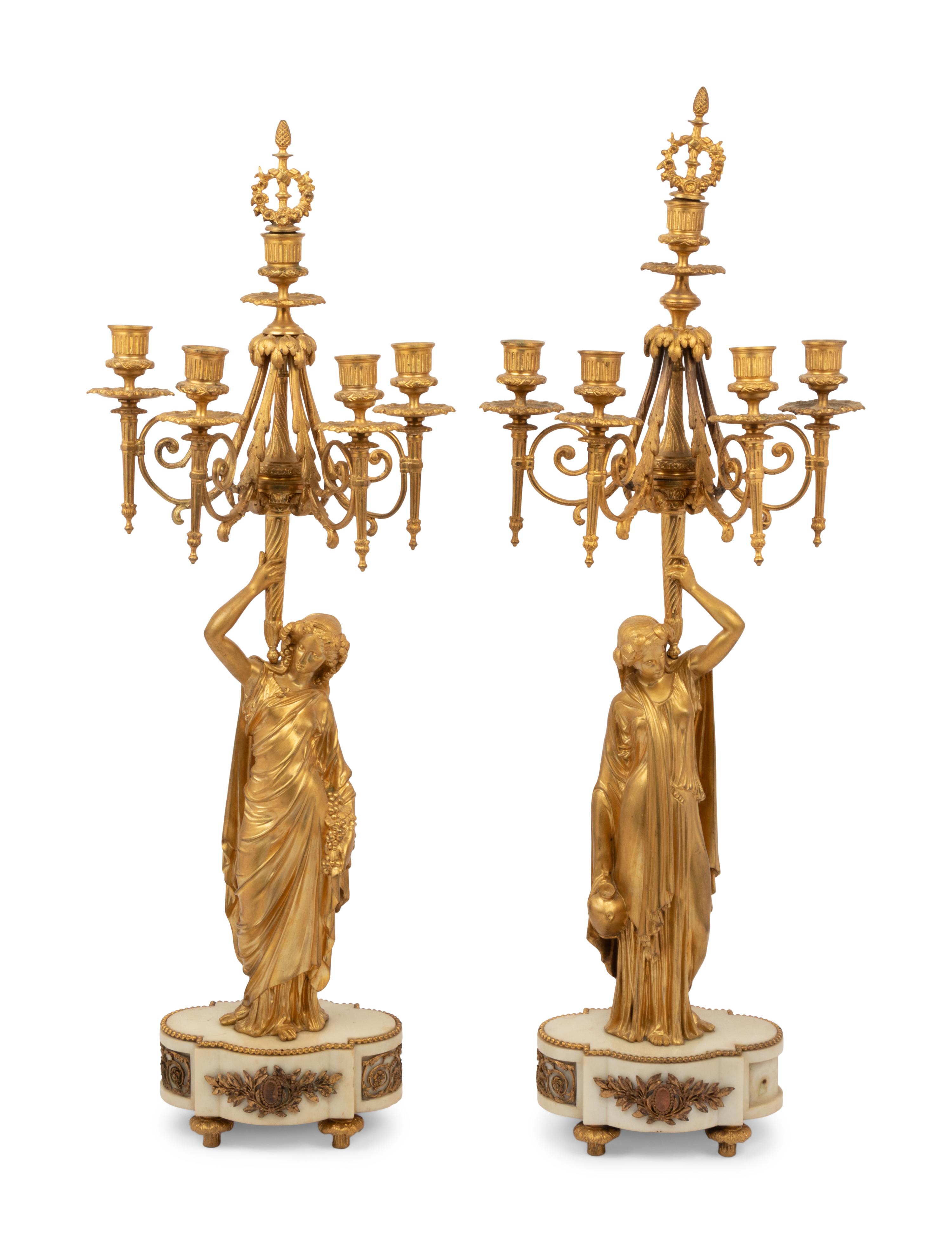 A Louis XVI Style Gilt Bronze and Marble Figural Clock Garniture