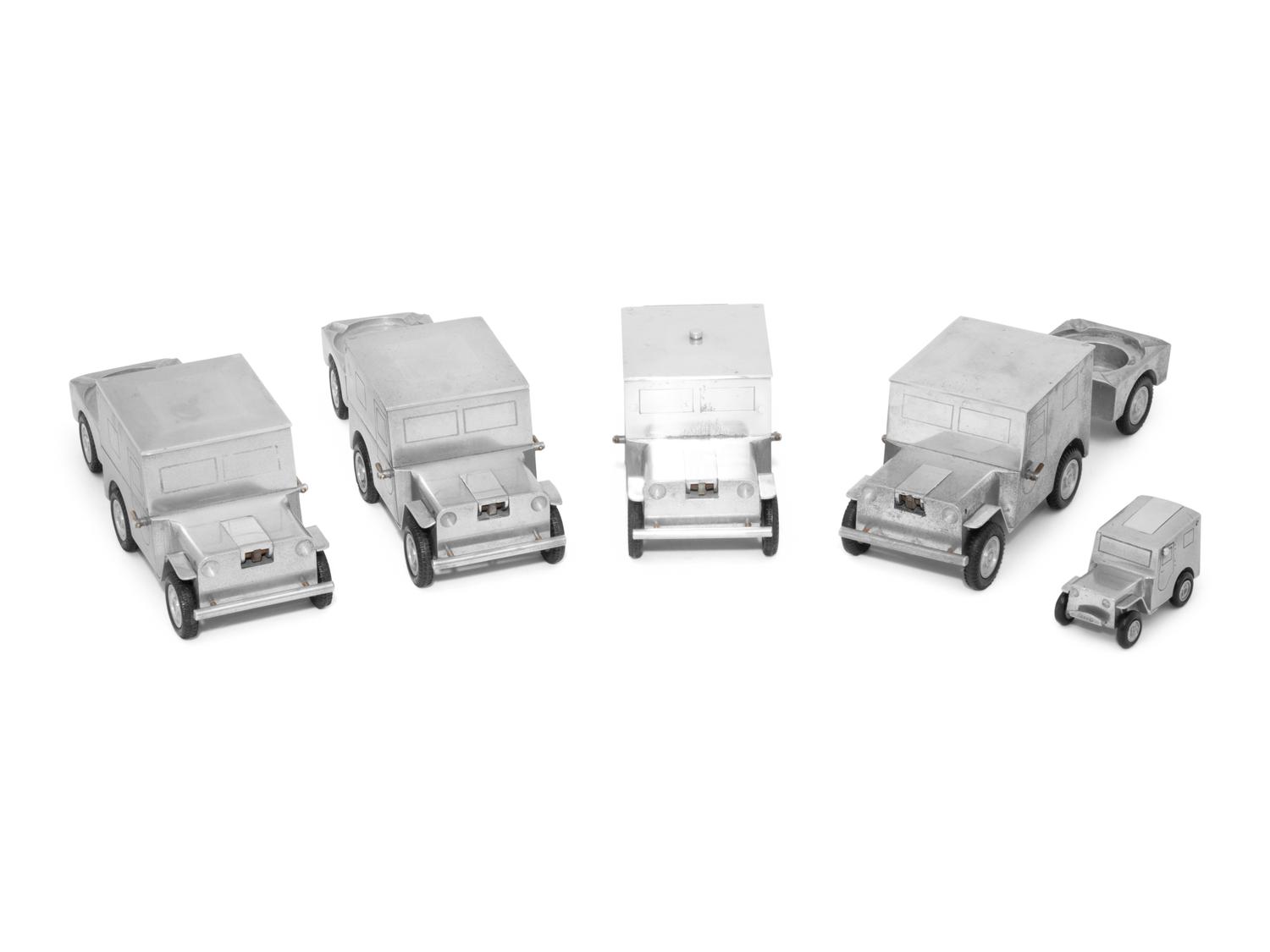 A Set of Four German Vehicle-Form Metal Cigarette Box, Lighter and Ashtray Sets