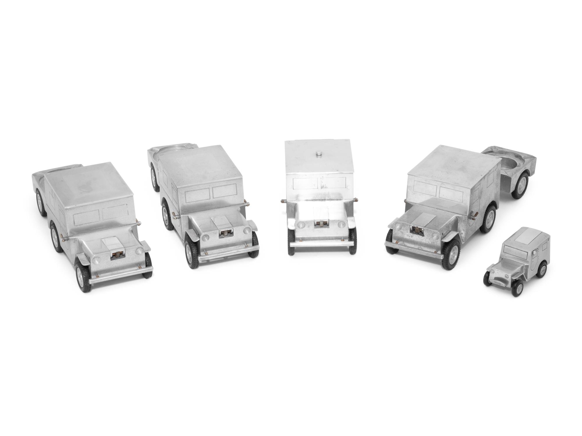A Set of Four German Vehicle-Form Metal Cigarette Box, Lighter and Ashtray Sets