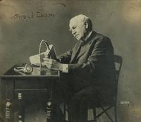 [EDISON, Thomas (1847-1931)]. LUEDER, Lewis, photographer. Portrait of Thomas Edison with an electric mine lamp, signed by Edison. Ca 1923.