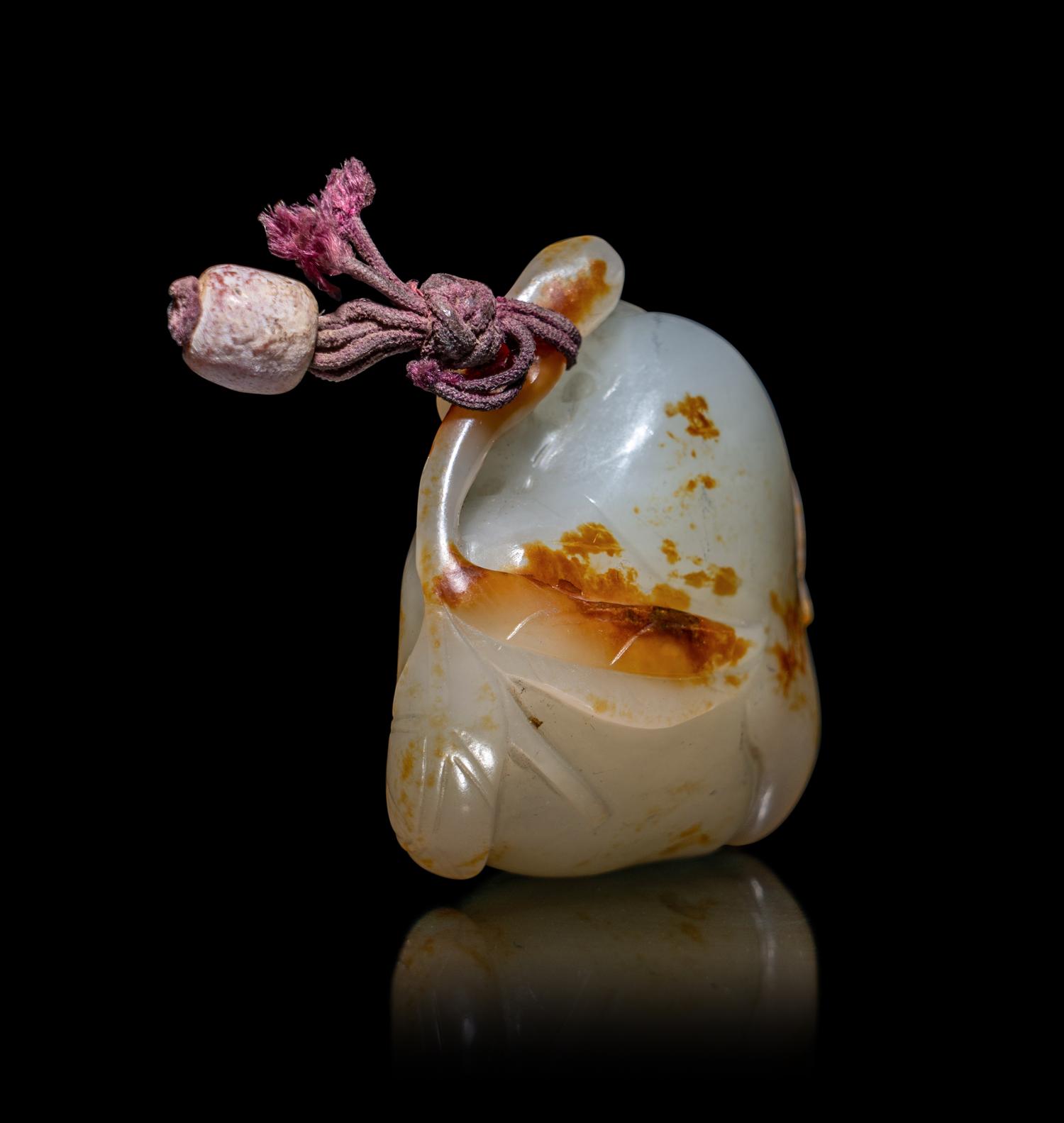 A Chinese Russet and White Jade 'Peach and Bat' Pendant
