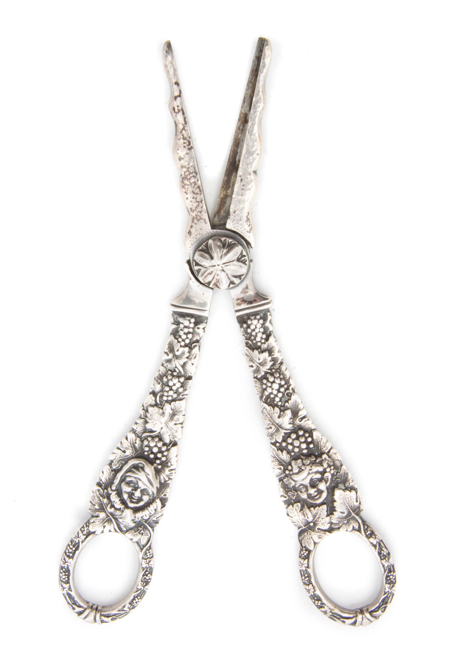 A Pair of Silver Grape Shears, Georg Jensen, of typical form, decorated with figures amongst grape vines.