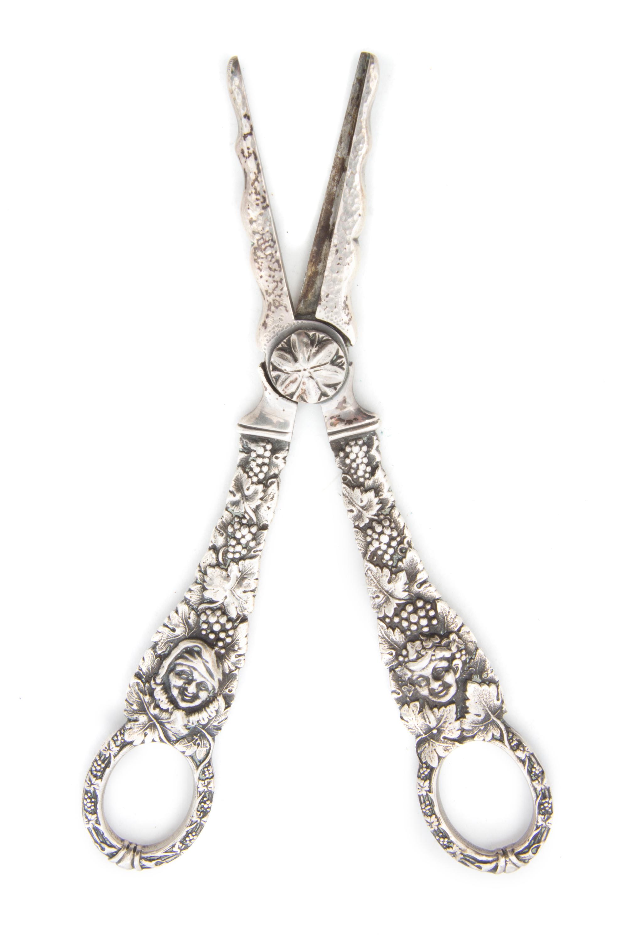 A Pair of Silver Grape Shears, Georg Jensen, of typical form, decorated with figures amongst grape vines.