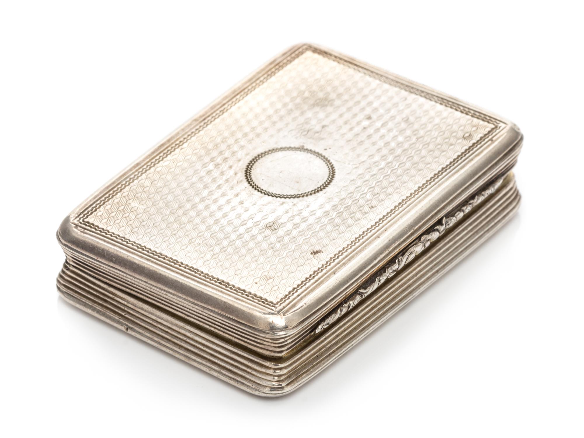 A Silver Vinaigrette, With spurious Georgian marks, having an engine turned decorated case centered by a vacant cartouche.