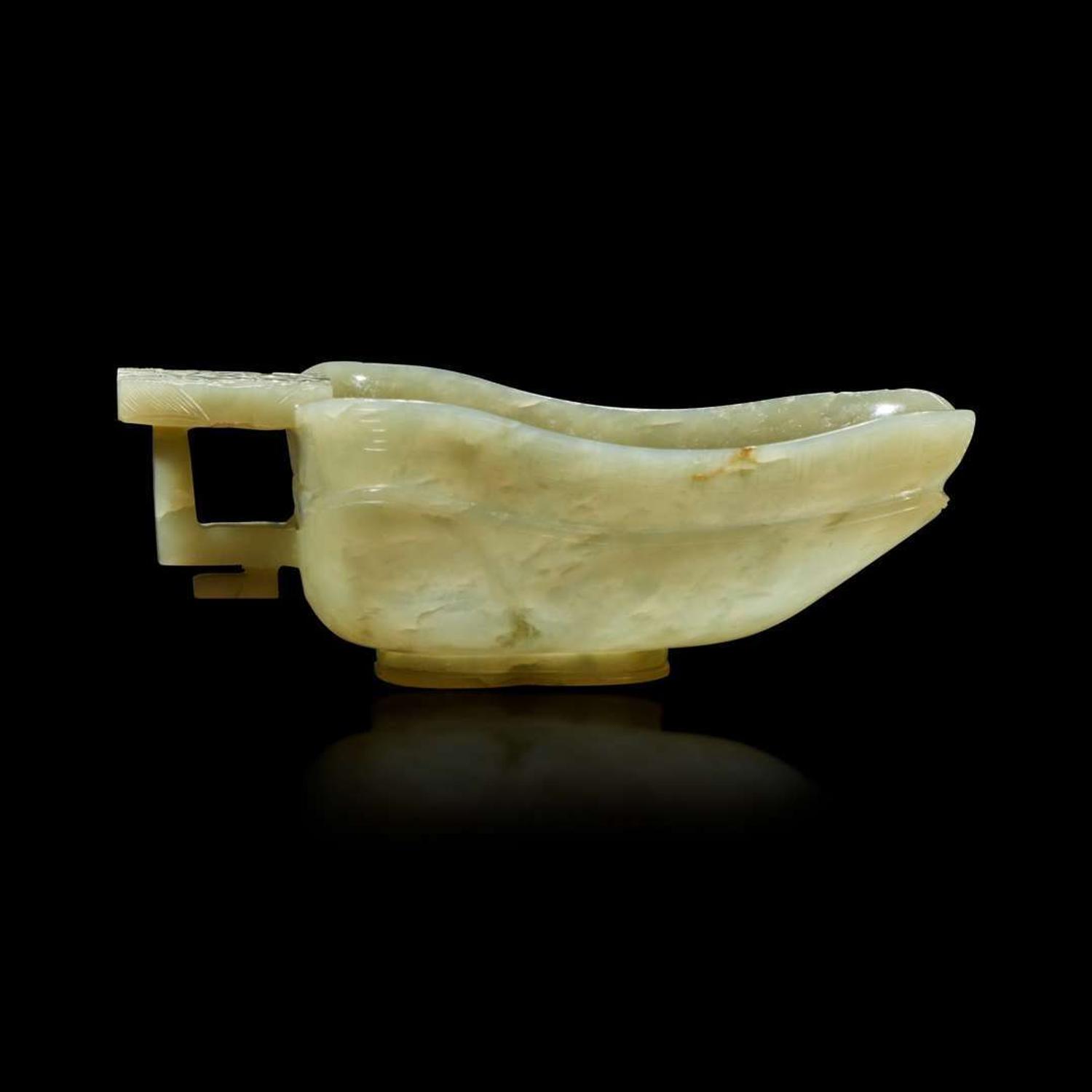 A Chinese celadon jade libation cup, Yi, and a carved grey-white jade oval "Dragon" plaque the jades late Ming to Qing Dynasty