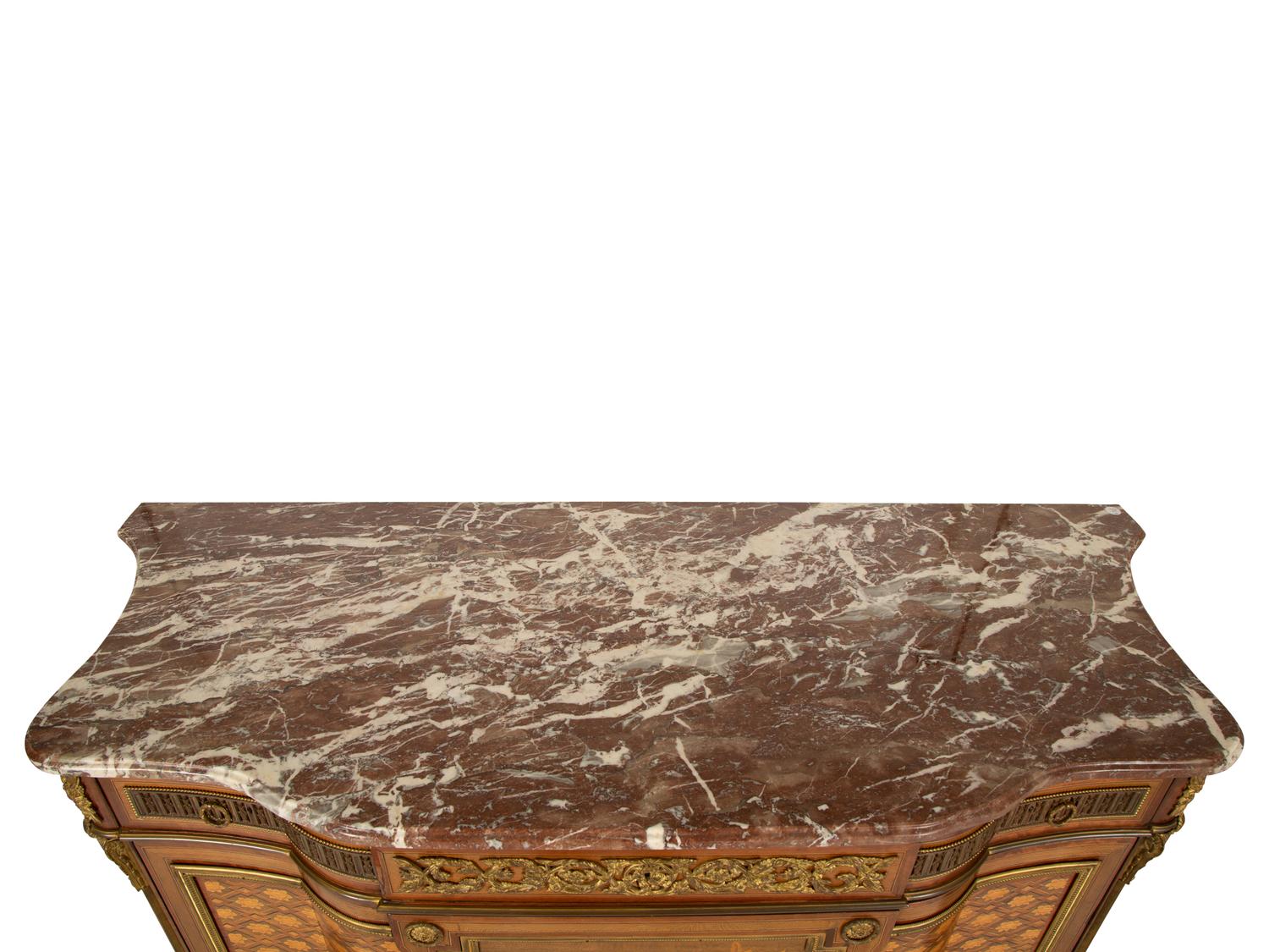 A Louis XVI Style Gilt Bronze Mounted Kingwood and Marquetry Marble-Top Commode