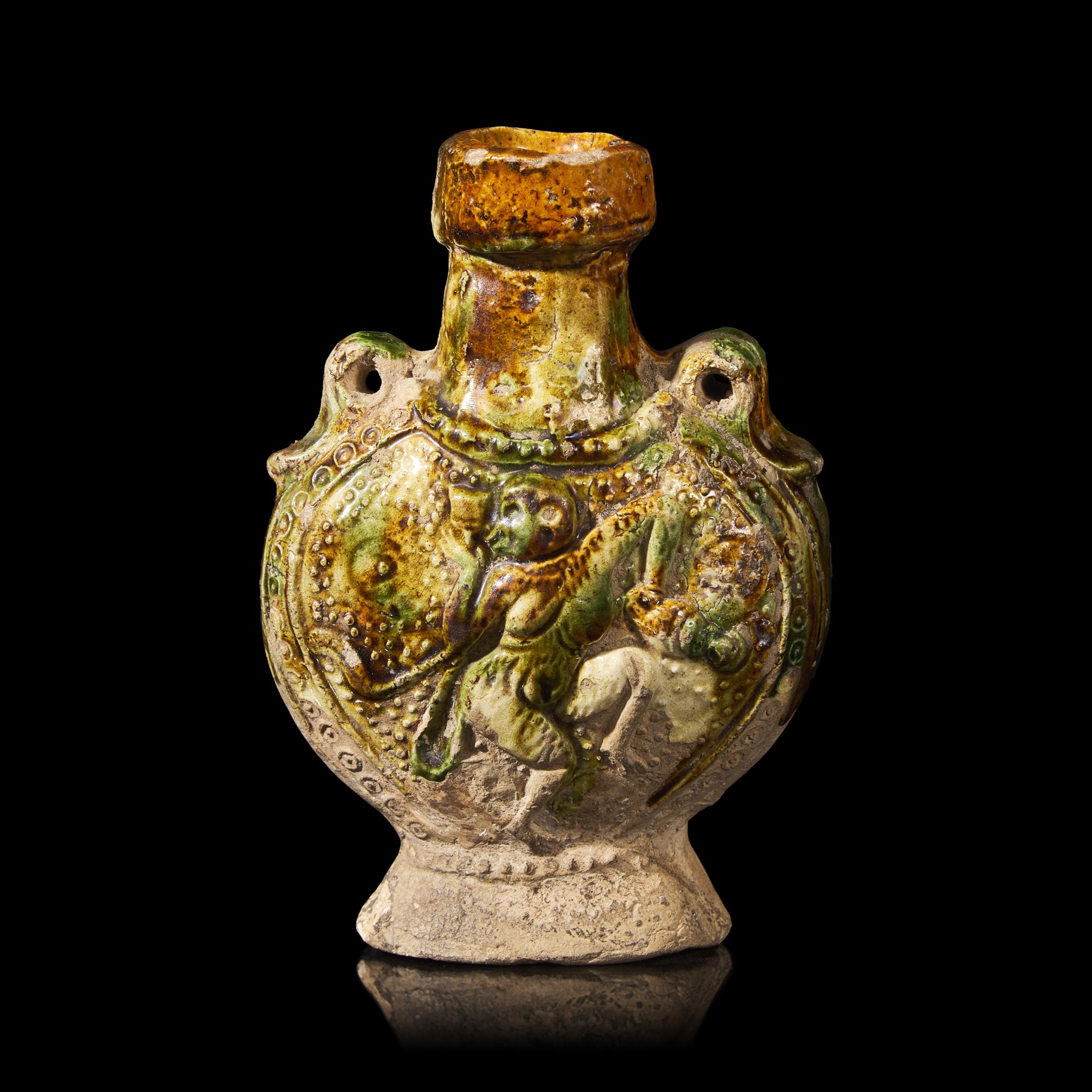 A Chinese Molded Sancai-Glazed Pottery Pilgrim Flask, Tang Dynasty 唐 三彩模印樂舞圖雙繫扁壺