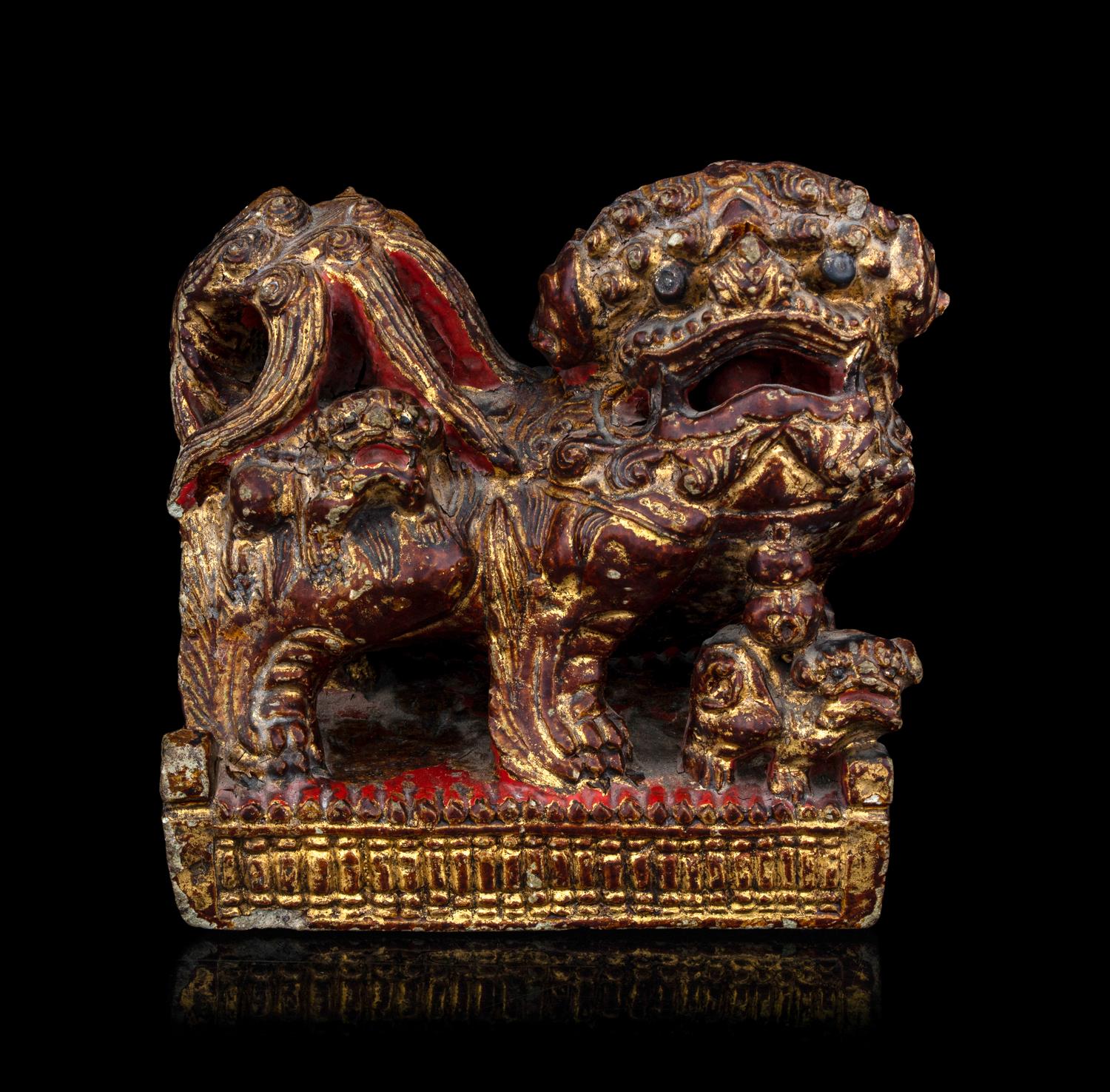 A Chinese Gilt and Red Painted Stone Fu Lion