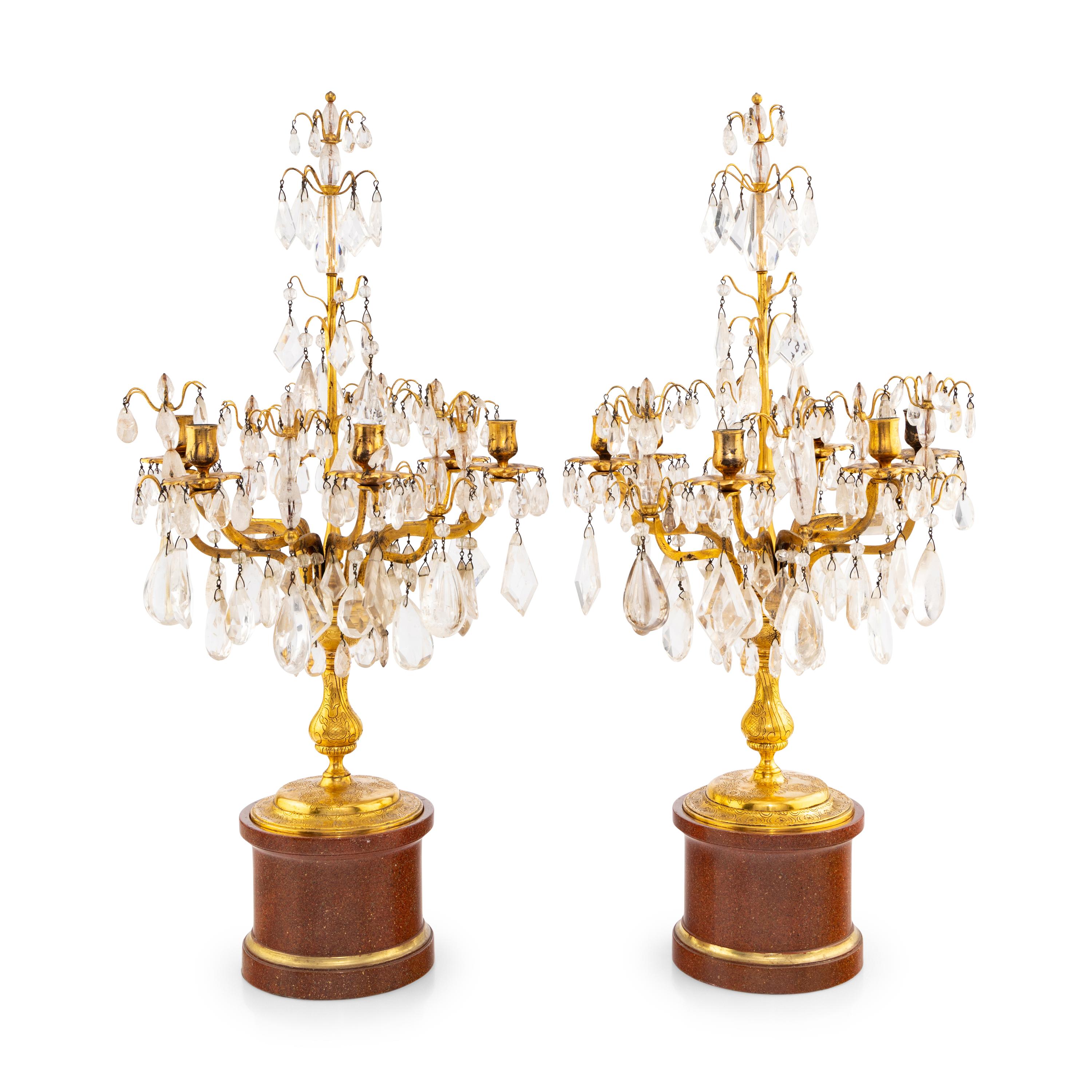 A Pair of Régence Style Rock Crystal, Cut Glass and Engraved Gilt Bronze Six-Light Candelabra on Simulated Porphyry Bases