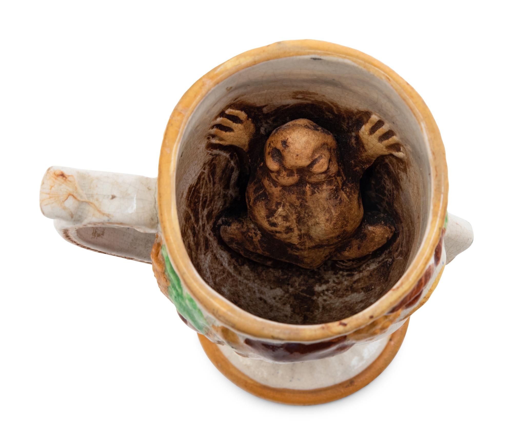A Staffordshire Pottery Satyr Mug with an Interior Frog