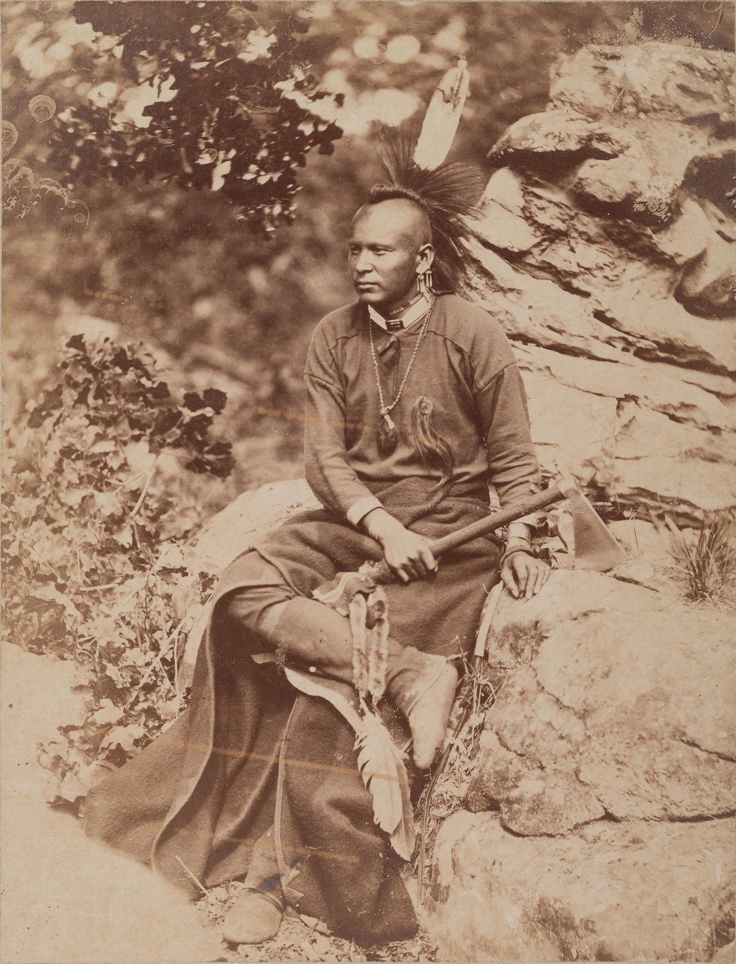 HILLERS, John K. (1843-1925), photographer. Photograph of an Osage warrior holding a tomahawk. Okmulgee, Indian Territory, 1875.