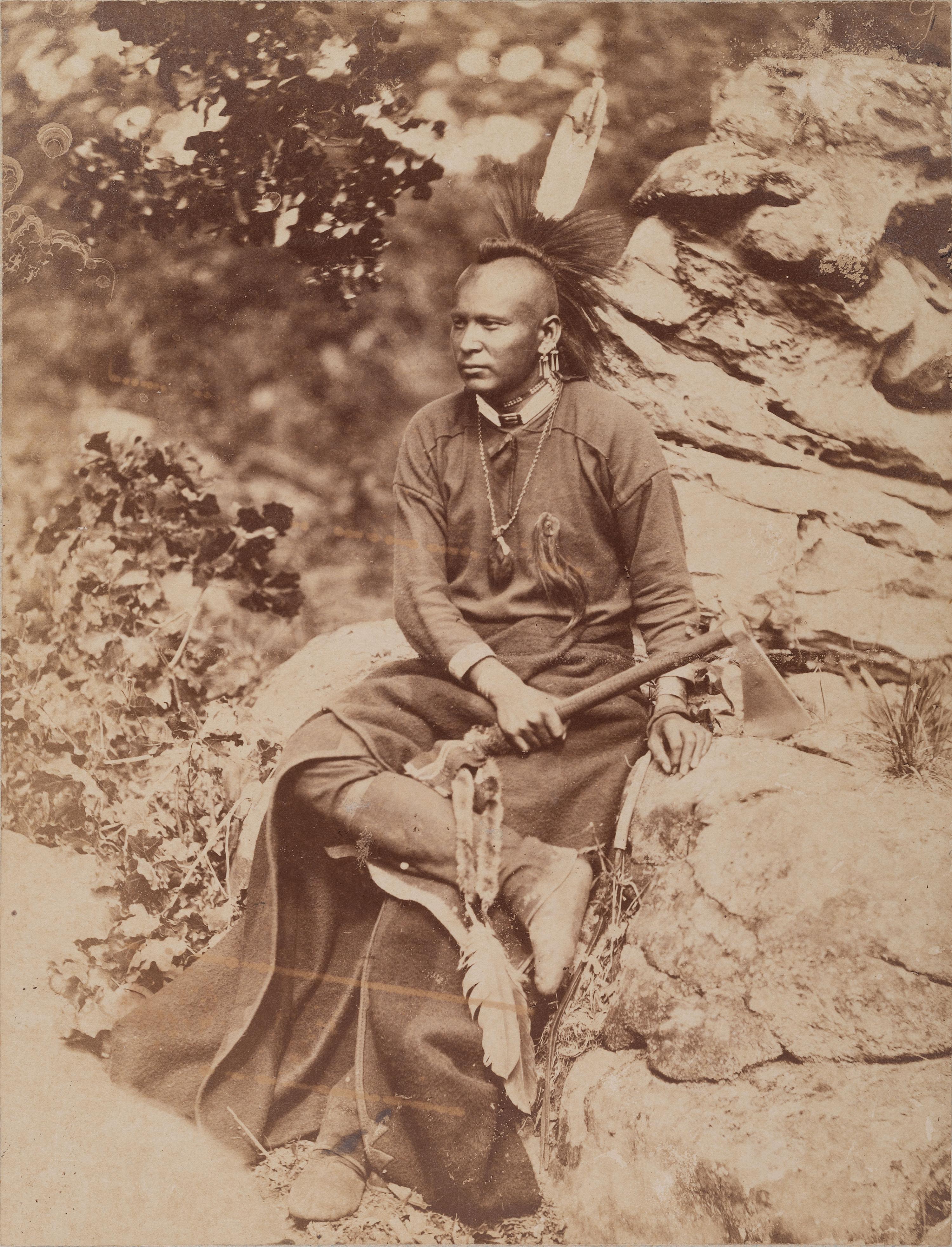 HILLERS, John K. (1843-1925), photographer. Photograph of an Osage warrior holding a tomahawk. Okmulgee, Indian Territory, 1875.