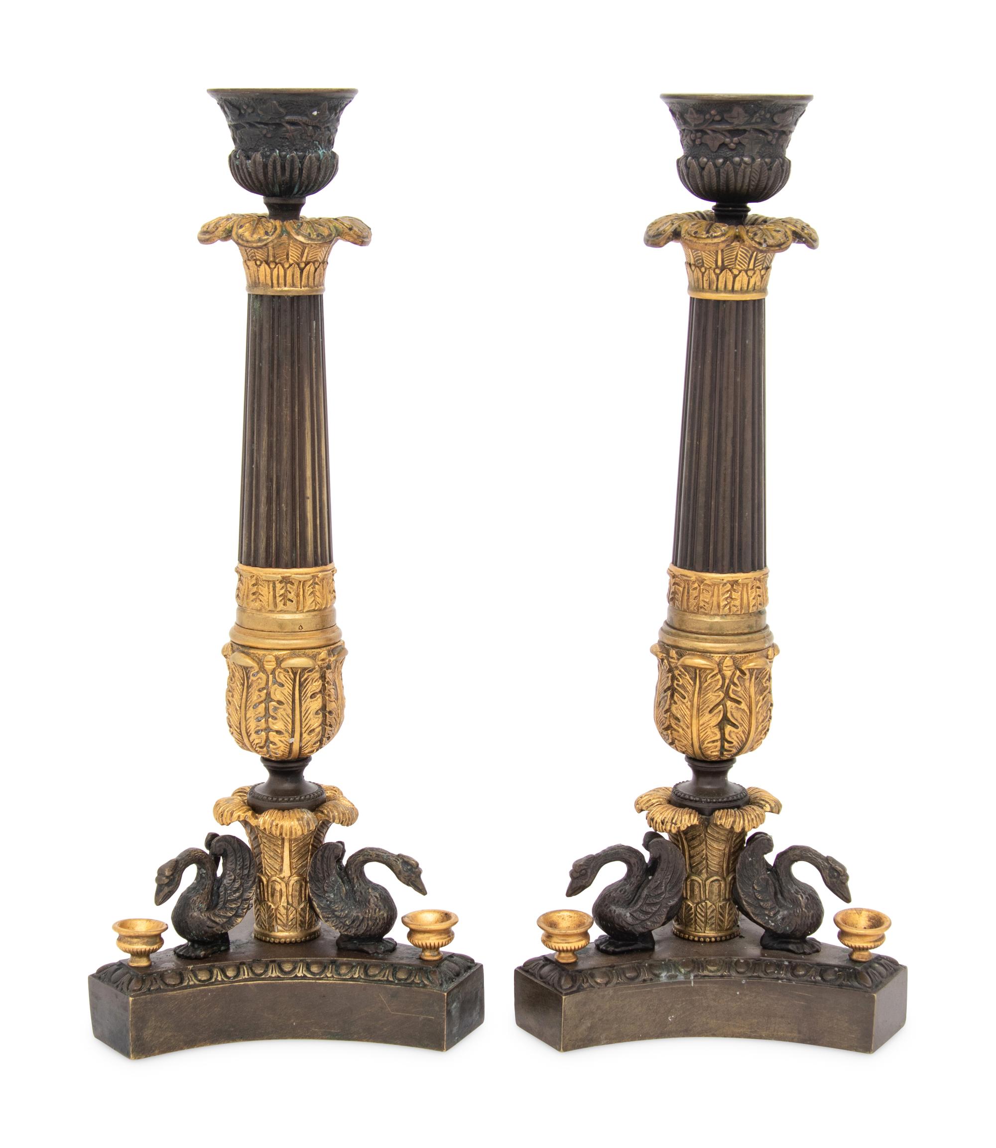 A Pair of French Parcel Gilt and Patinated Bronze Candlesticks
