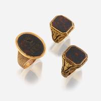 A collection of three gold and bloodstone men's rings