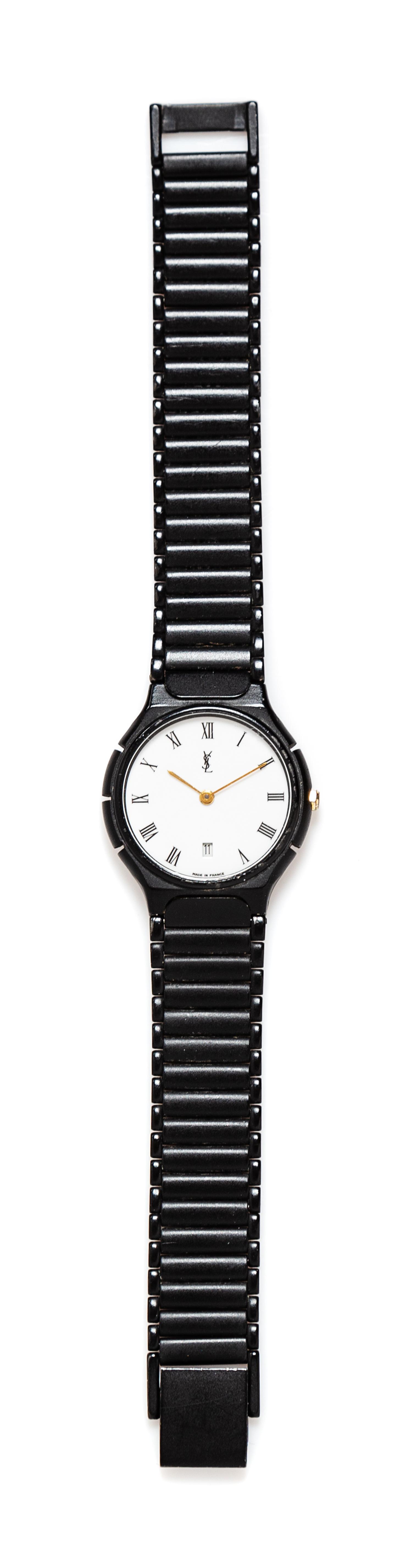 An Yves Saint Black Quartz Wristwatch, 7" L x .5" W; Face: 1" diameter.