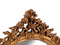 A Pair of Italian Carved Giltwood Oval Mirrors