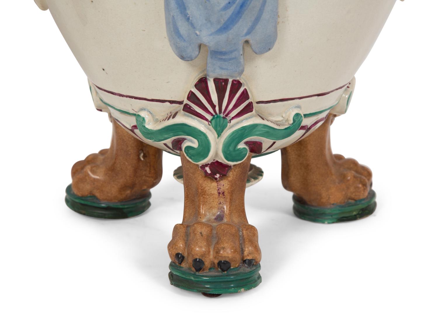 A Pair of Italian Glazed Ceramic Urns Decorated with Horned Masks and Paw Feet