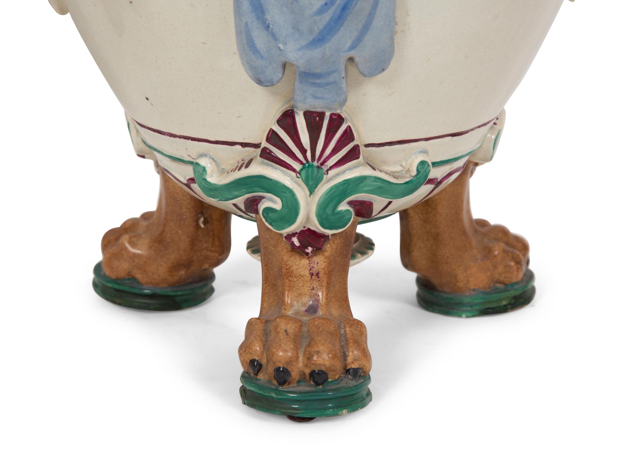 A Pair of Italian Glazed Ceramic Urns Decorated with Horned Masks and Paw Feet