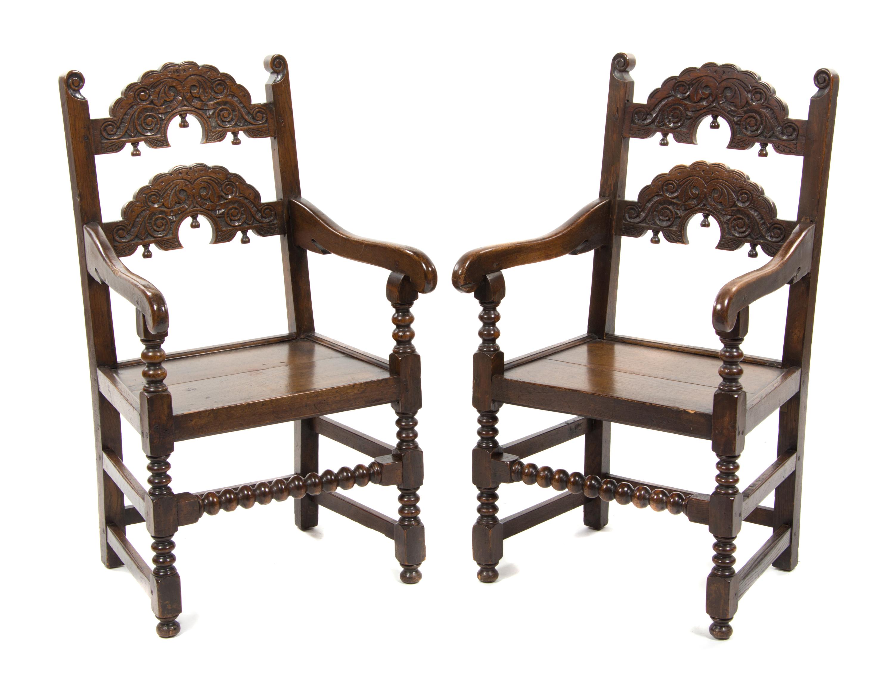 A Pair of Jacobean Revival Carved Oak Open Armchairs, Height 41 inches.