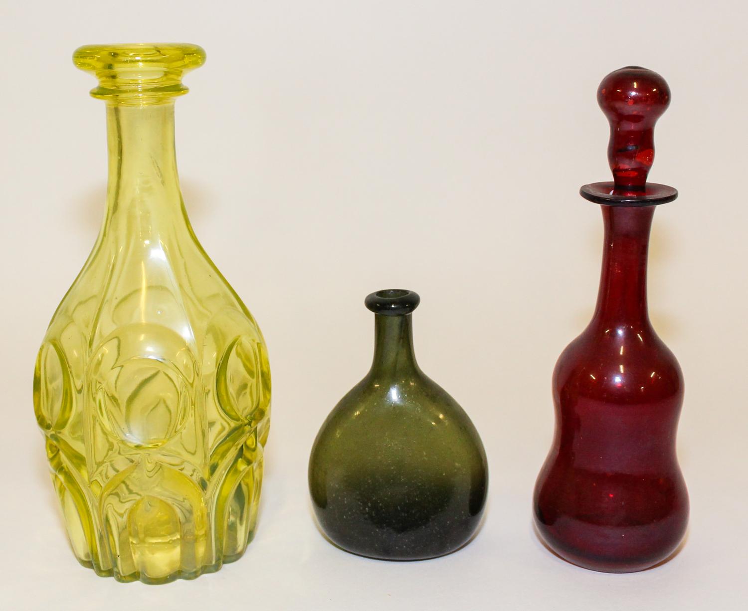 A Group of Three Glass Bottles Height of tallest 11 inches.