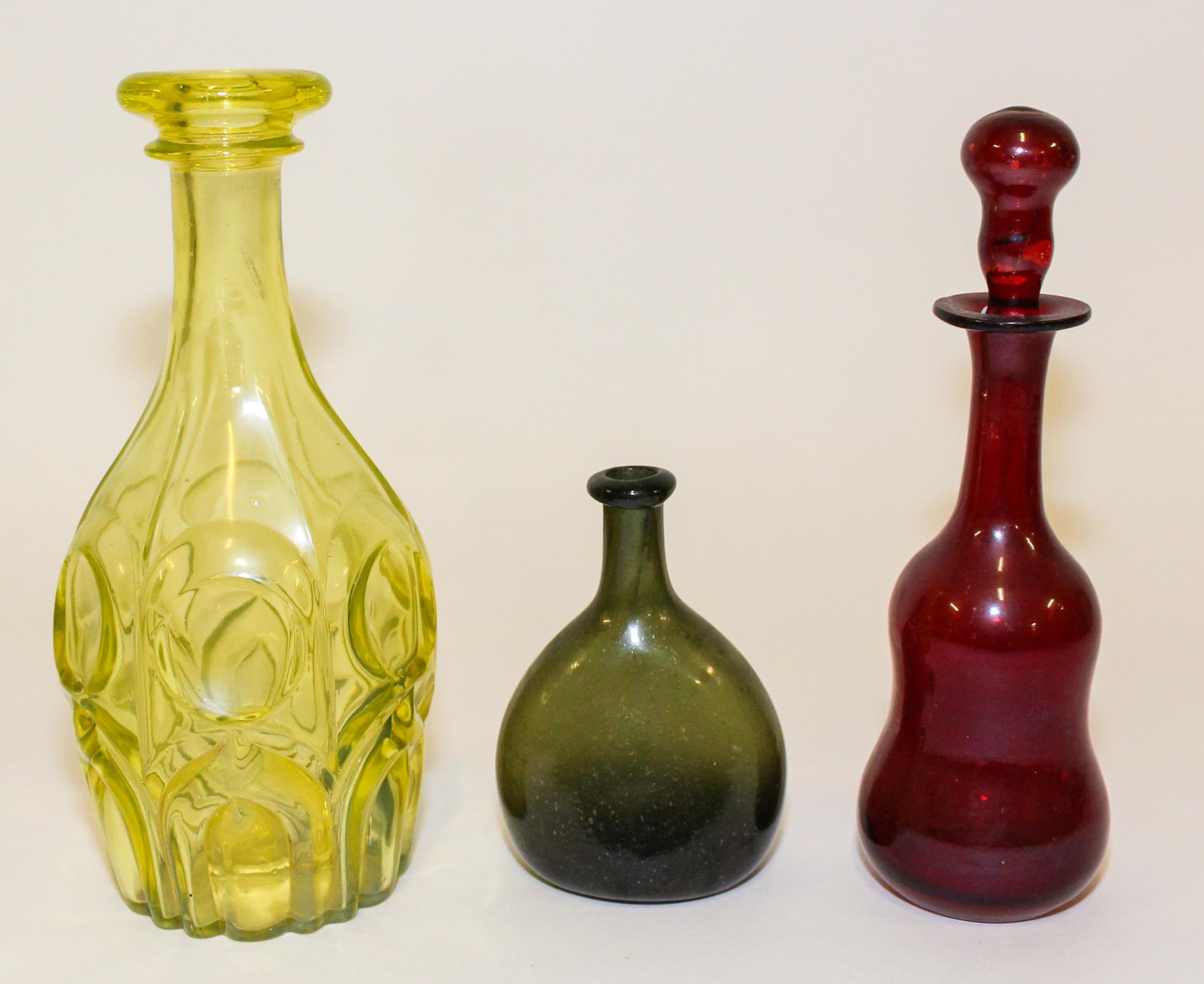 A Group of Three Glass Bottles Height of tallest 11 inches.
