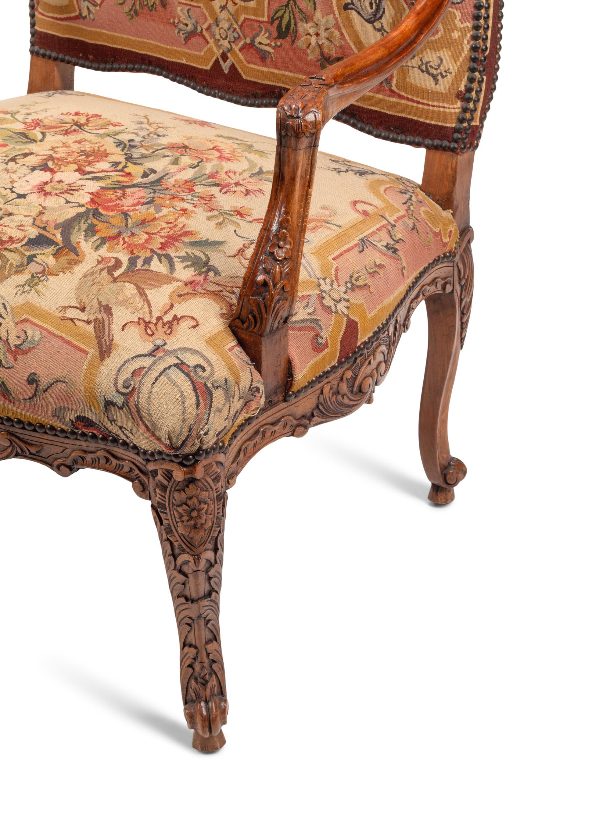 A Pair of Régence Style Carved Walnut and Tapestry-Upholstered Armchairs