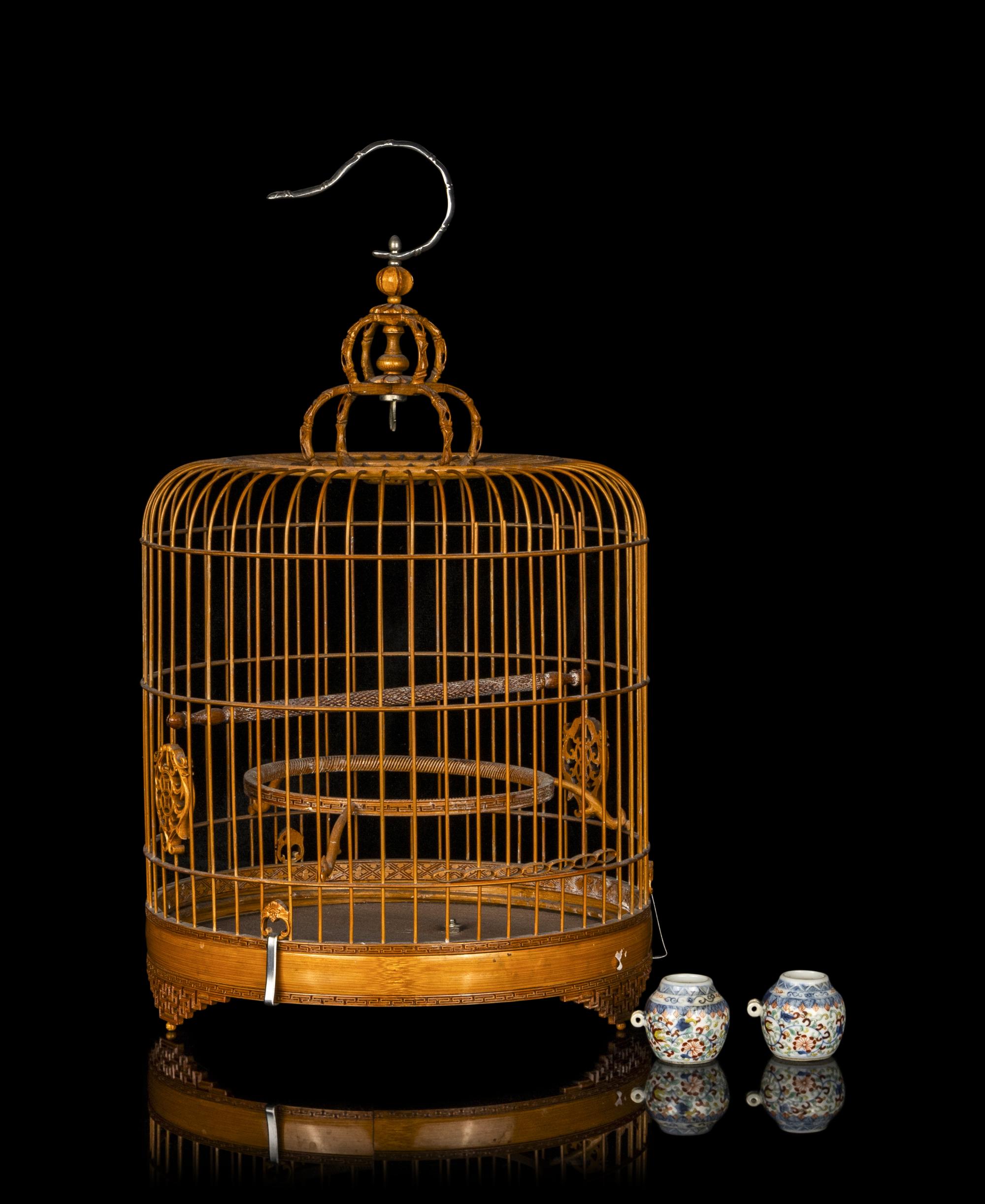 A Chinese Bamboo Bird Cage with A Pair of Wucai Porcelain Bird Feeders