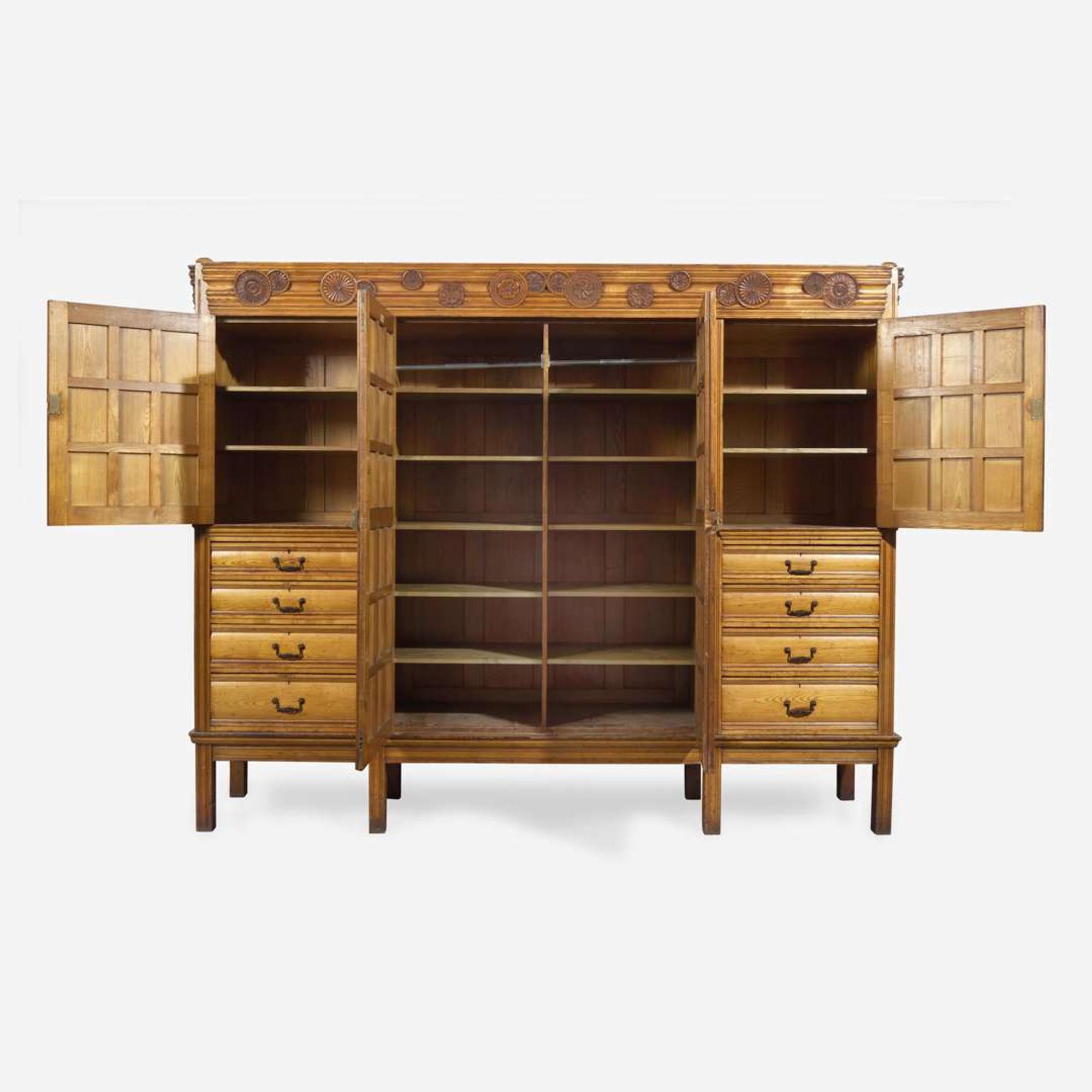 A large English Aesthetic Movement oak wardrobe Attributed to Richard Norman Shaw (1831-1912) & William Eden Nesfield (1835-1888), retailed by Maple & Co. (est. 1841), London, England, circa 1870