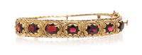 A 14 Karat Yellow Gold Garnet and Bangle Bracelet, 19.50 dwts.