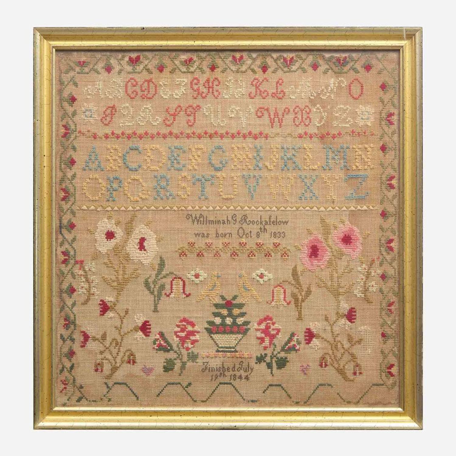 A Federal child's cherry slant-front desk together with a needlework sampler late 18th / early 19th century