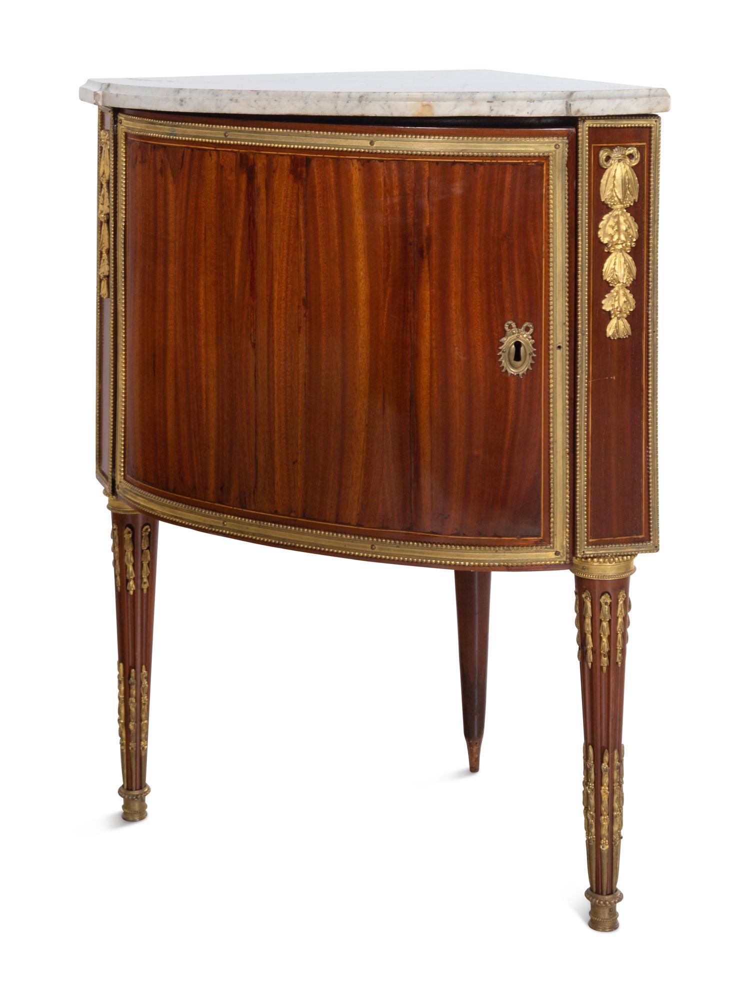 A Pair of Louis XVI Gilt Bronze Mounted Mahogany Marble-Top Encoignures by Charles Topino (French, 1742-1803)