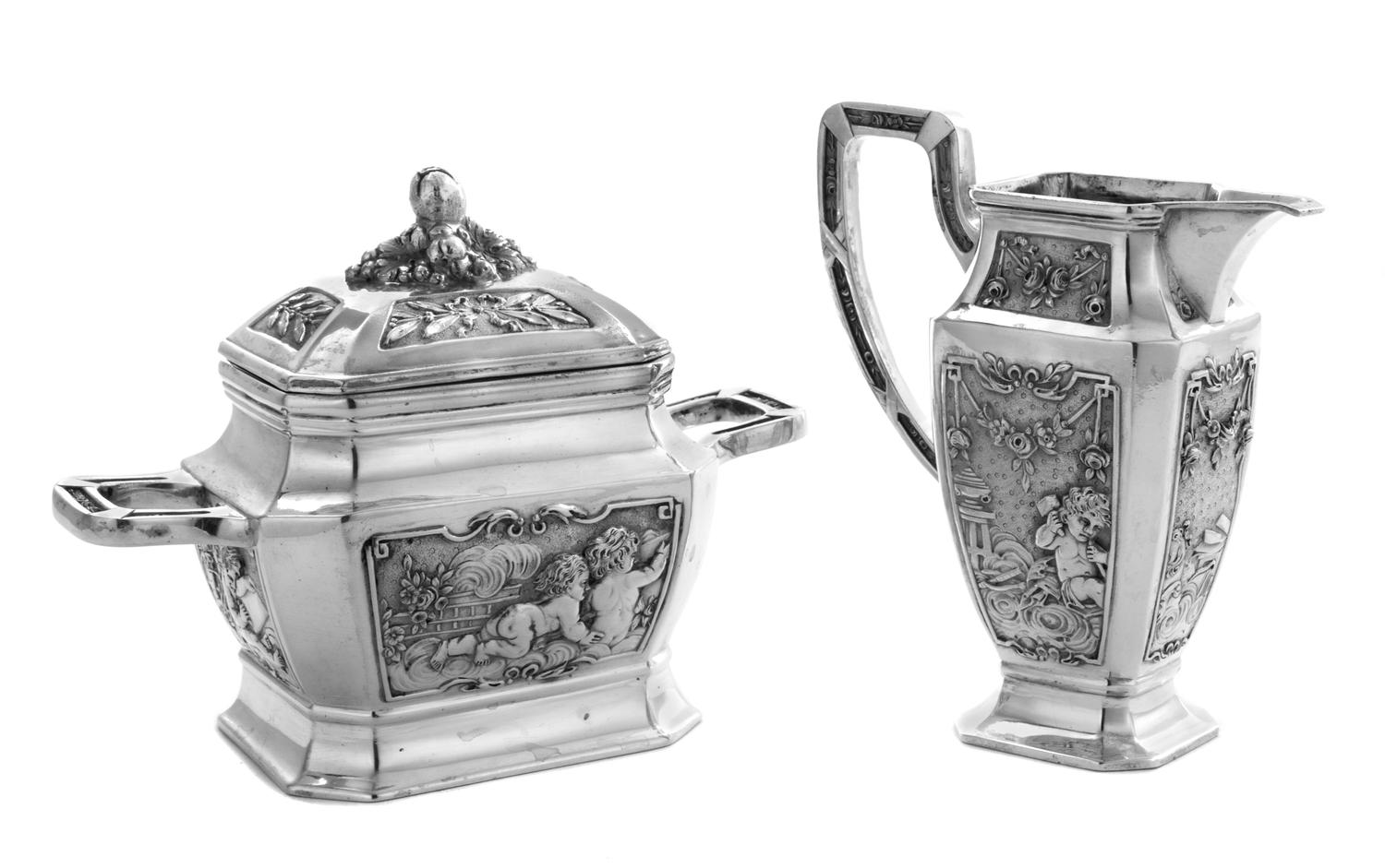 A German Silver Creamer and Sugar, Maker's Mark Obscured, Late 19th/Early 20th Century, each having a paneled body decorated with flora