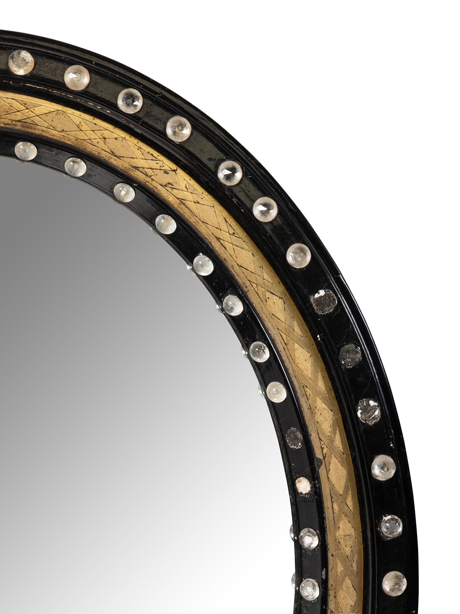 A Pair of Irish Ebonized and Parcel-Gilt Oval Mirrors