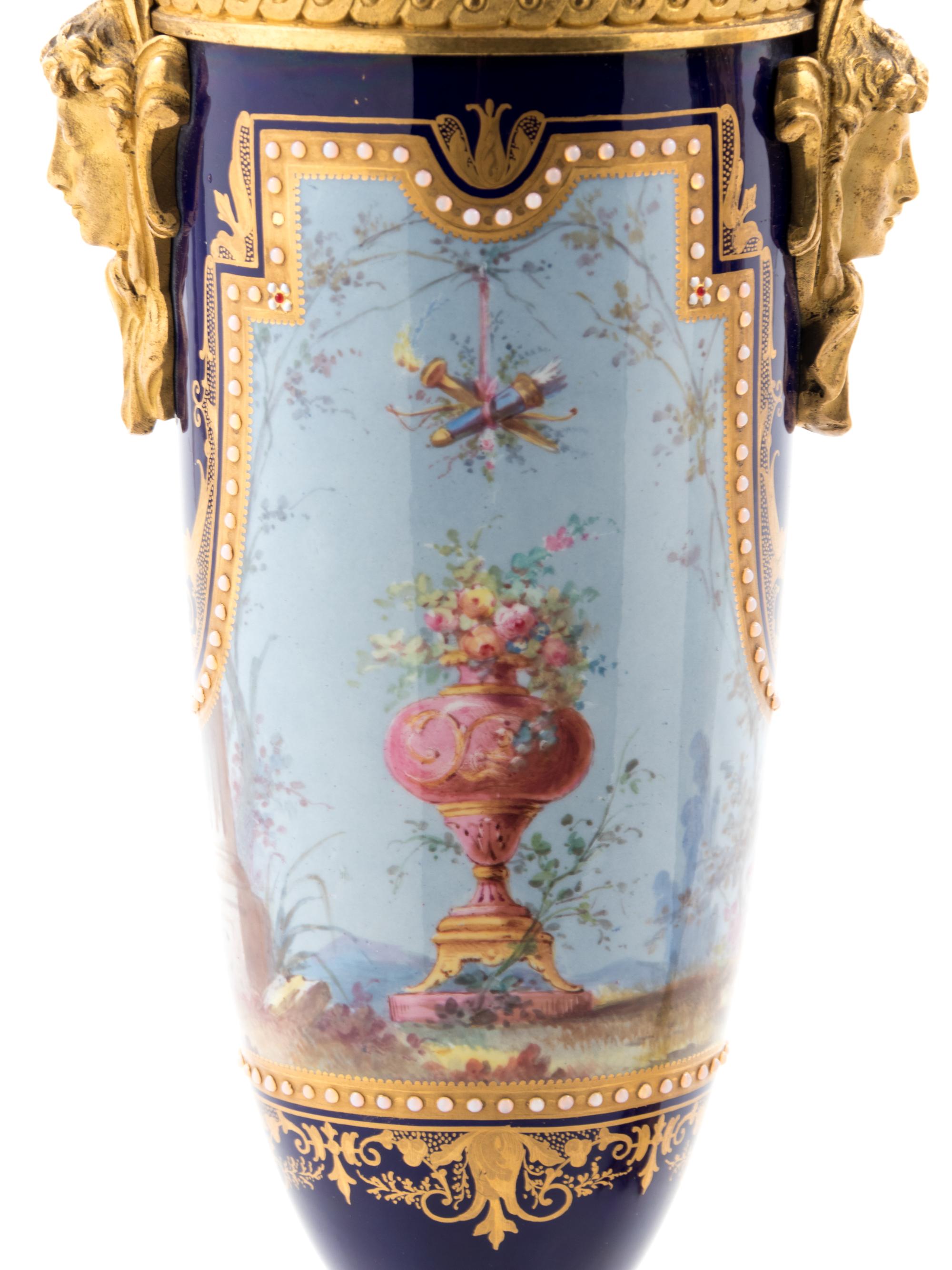 A Pair of Sèvres Style Gilt Bronze Mounted Painted, Parcel Gilt and "Jeweled" Porcelain Urns
