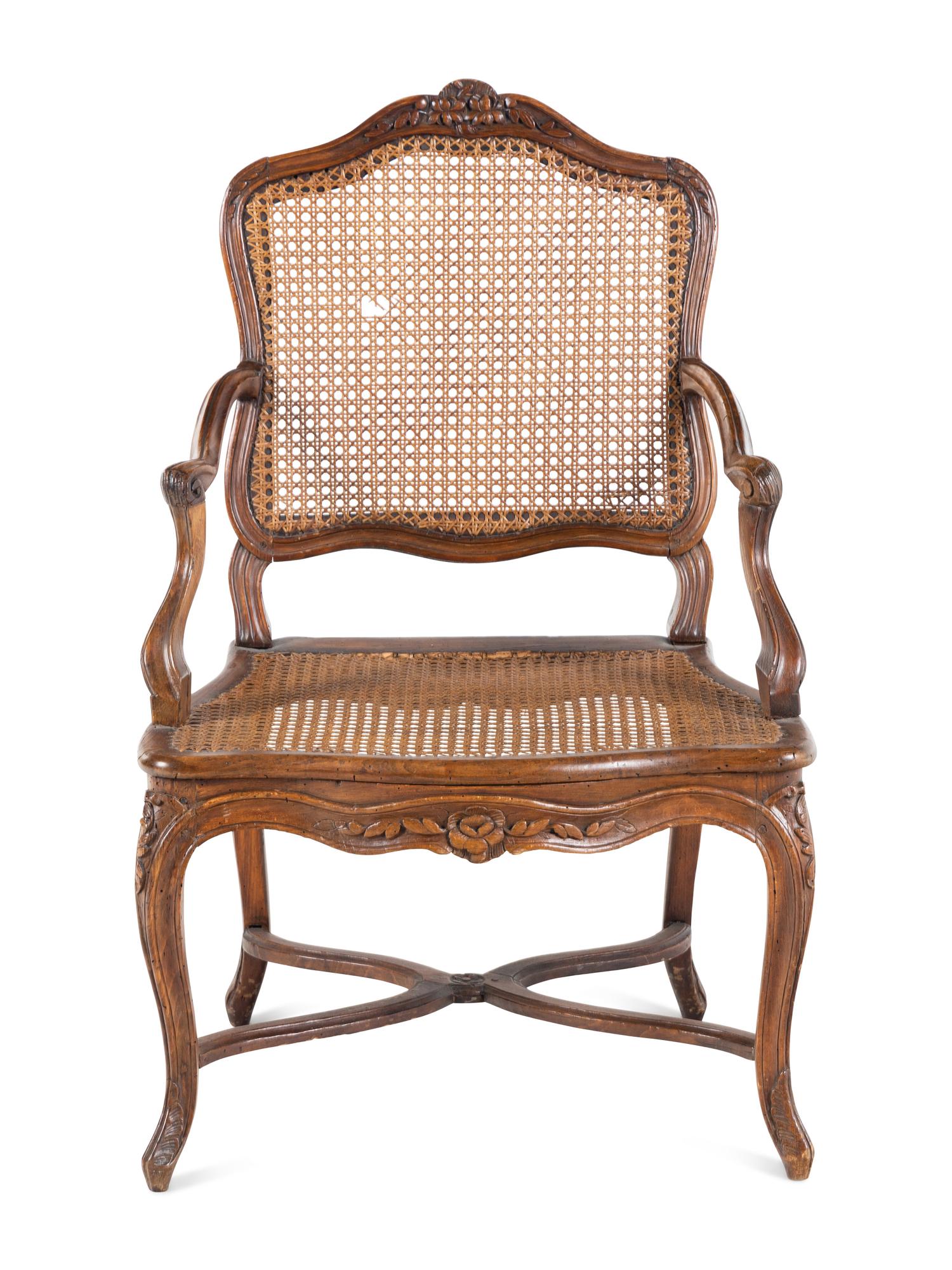 A Régence Carved Walnut and Caned Fauteuil