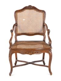 A Régence Carved Walnut and Caned Fauteuil