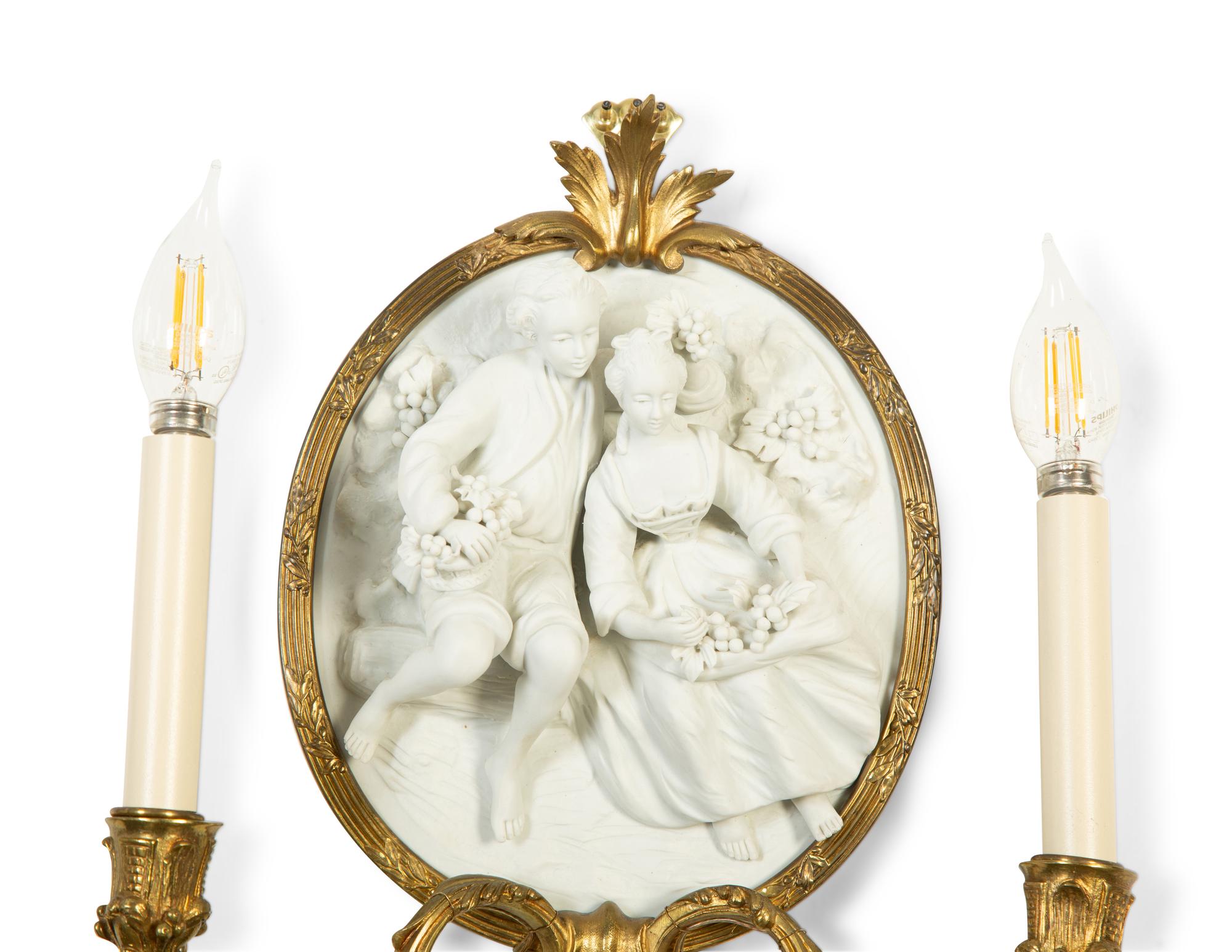 A Pair of Continental Plaster Relief Medallion and Gilt Bronze Two-Light Sconces